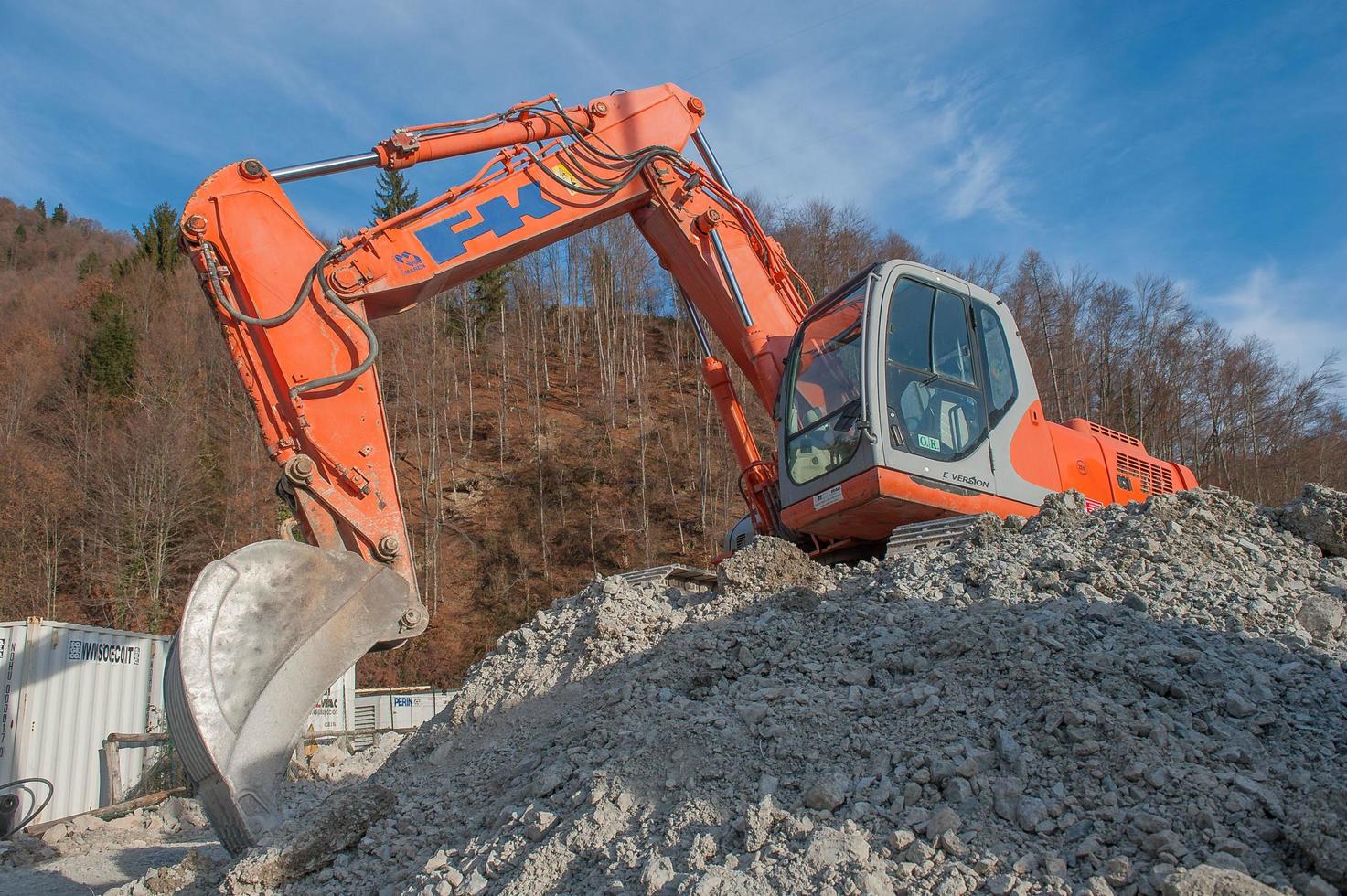 Bulldozer en el trabajo mientras carga camiones en gravera foto