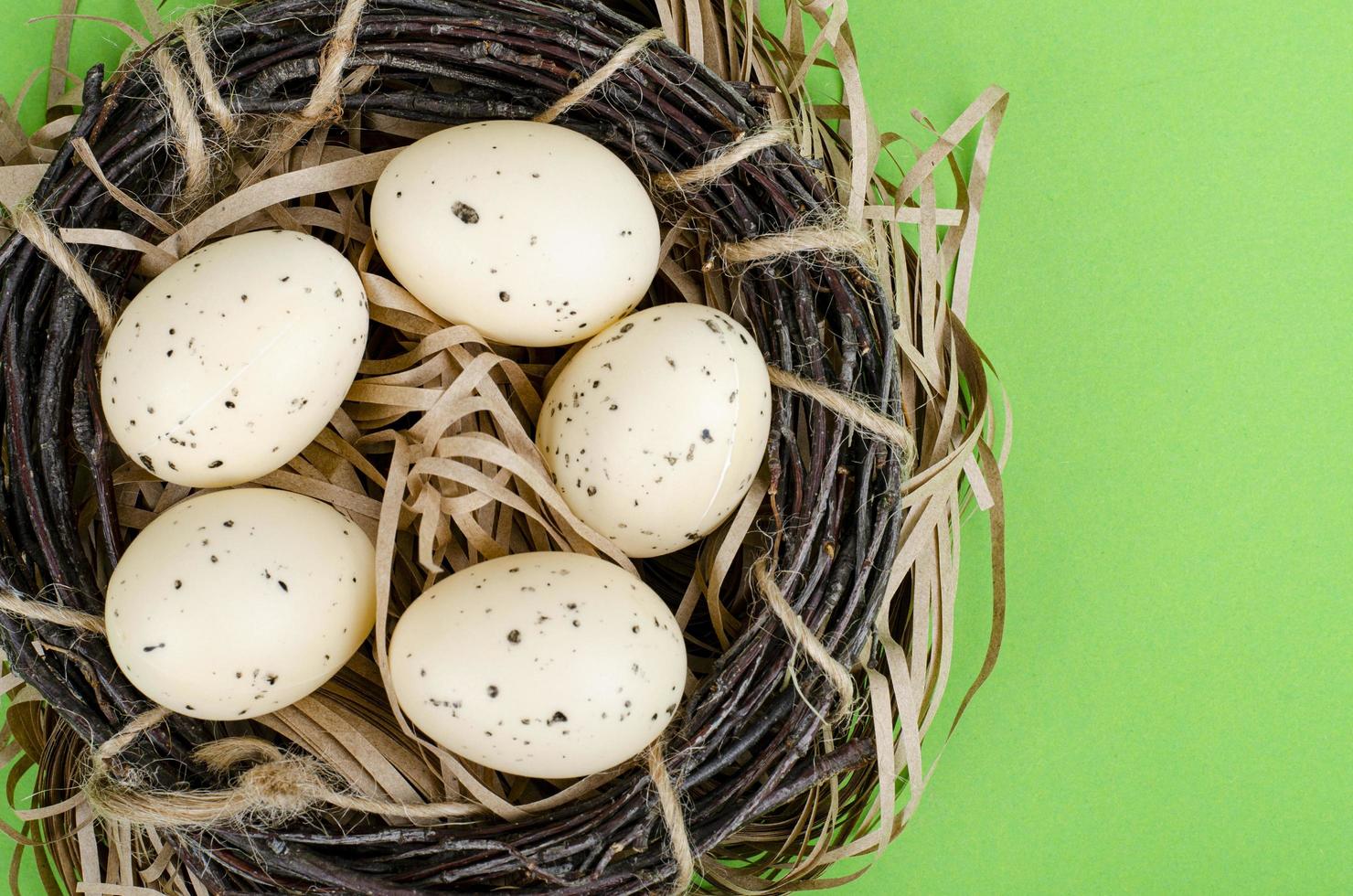 Top view of color easter haqndmade eggs and nest flatlay. Trendy minimal design spring background. Space for text. Stuio Photo