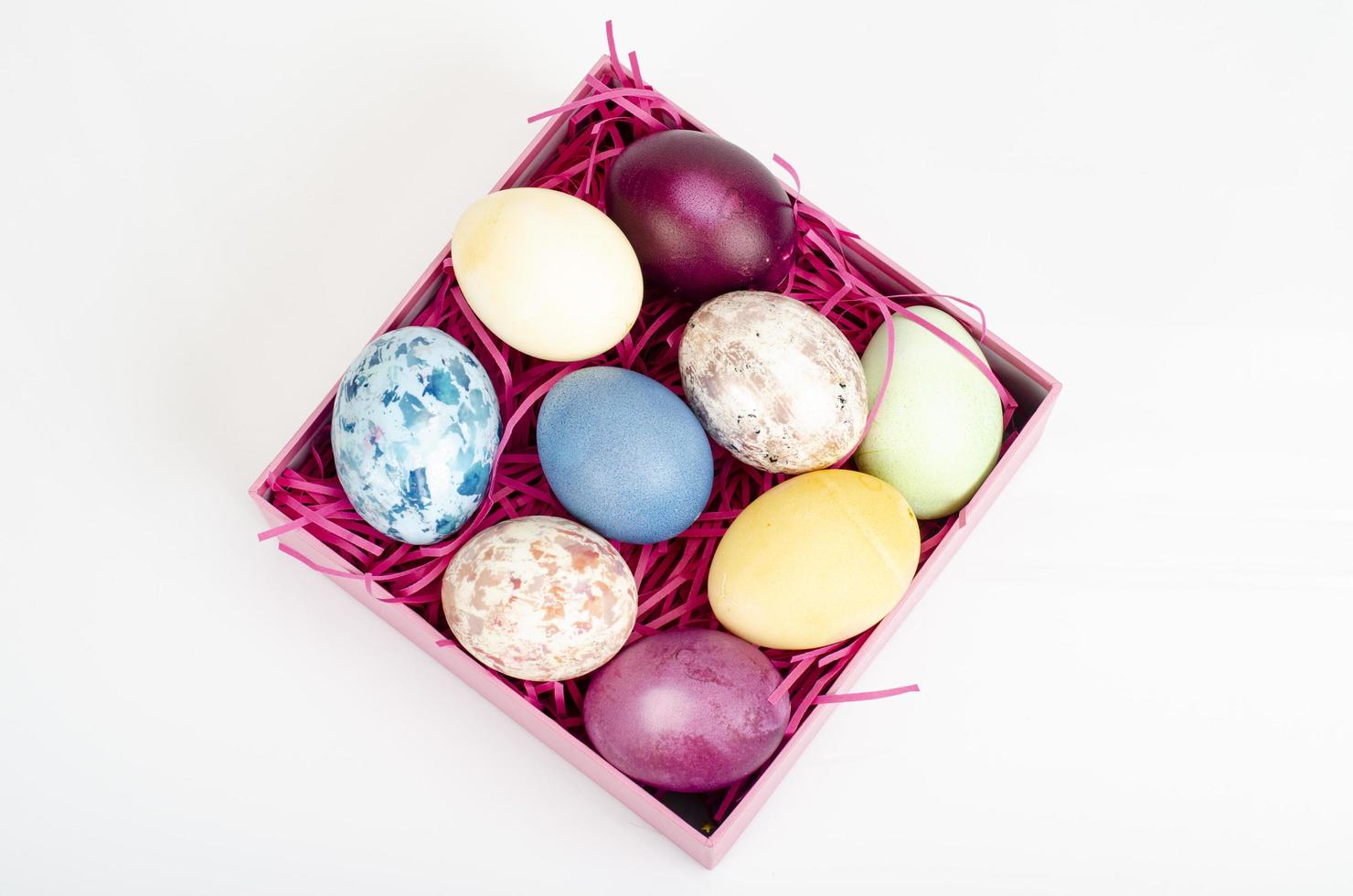 Multicolored eggs in open gift box. Concept of the Happy Easter holiday, greeting card template. Studio Photo