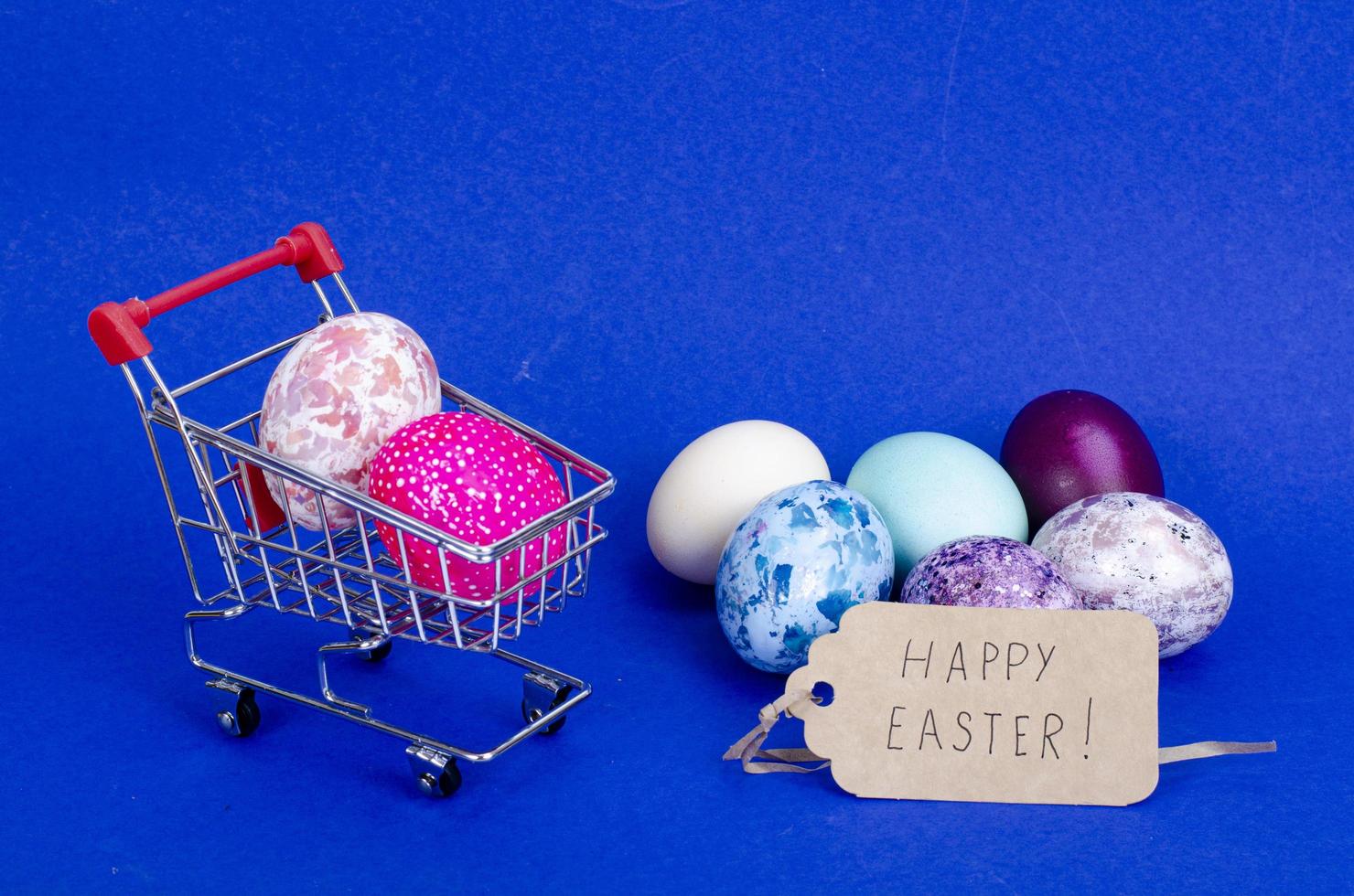 Grocery supermarket cart filled with chicken eggs. Concept of preparing for Easter, buying food. Space for text. Studio Photo