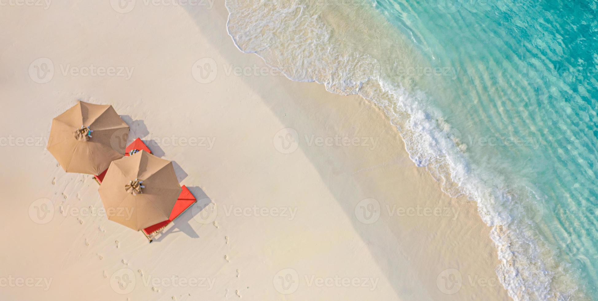 vista aérea de la increíble playa con sombrillas y tumbonas cerca del mar turquesa. vista superior del paisaje de la playa de verano, vacaciones idílicas e inspiradoras en pareja, vacaciones románticas. viajes de libertad foto