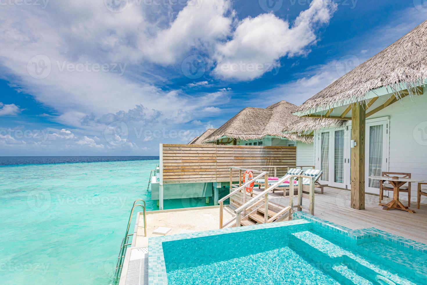 Overwater luxurious spa in the tropical blue lagoon of Maldives. Amazing private pool, chaise lounge wooden deck, terrace. Stunning sea view photo