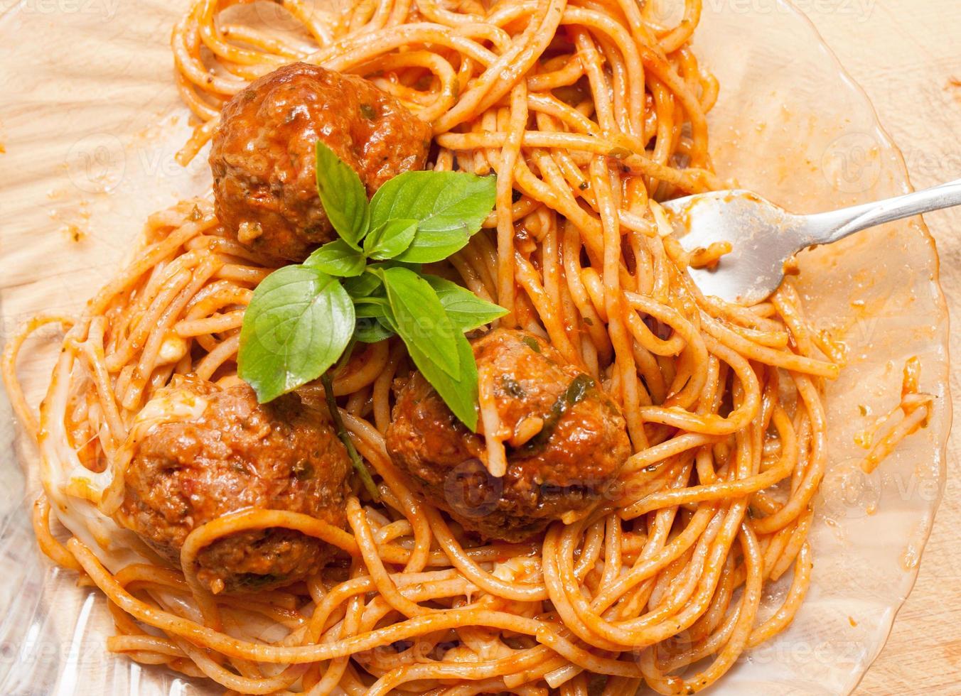 Homemade Spaghetti and Meatballs in Tomato Sauce with fresh Basil on Top photo