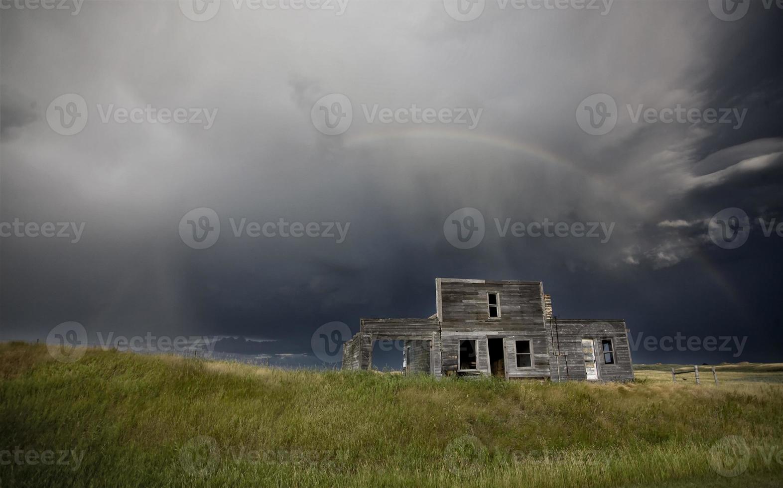 Storm over abandoned farm house photo