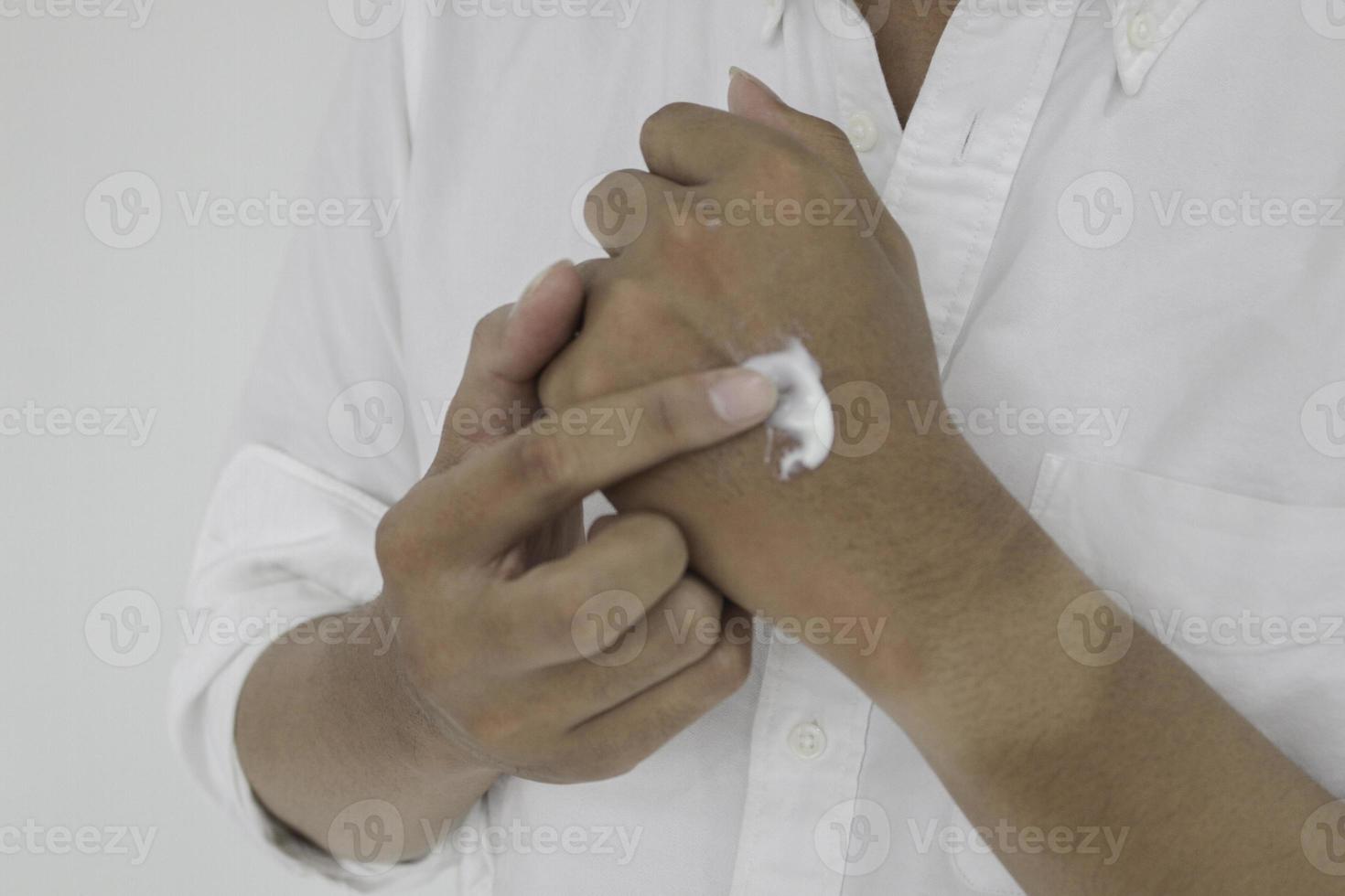 Asian handsome young man applying cream at his hand with smiley face, Skin care concept ,isolated on white background photo