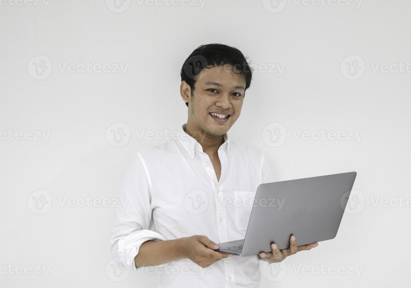 Young asian man is smile and enjoy when working at home with laptop computer. Work from home concept. photo