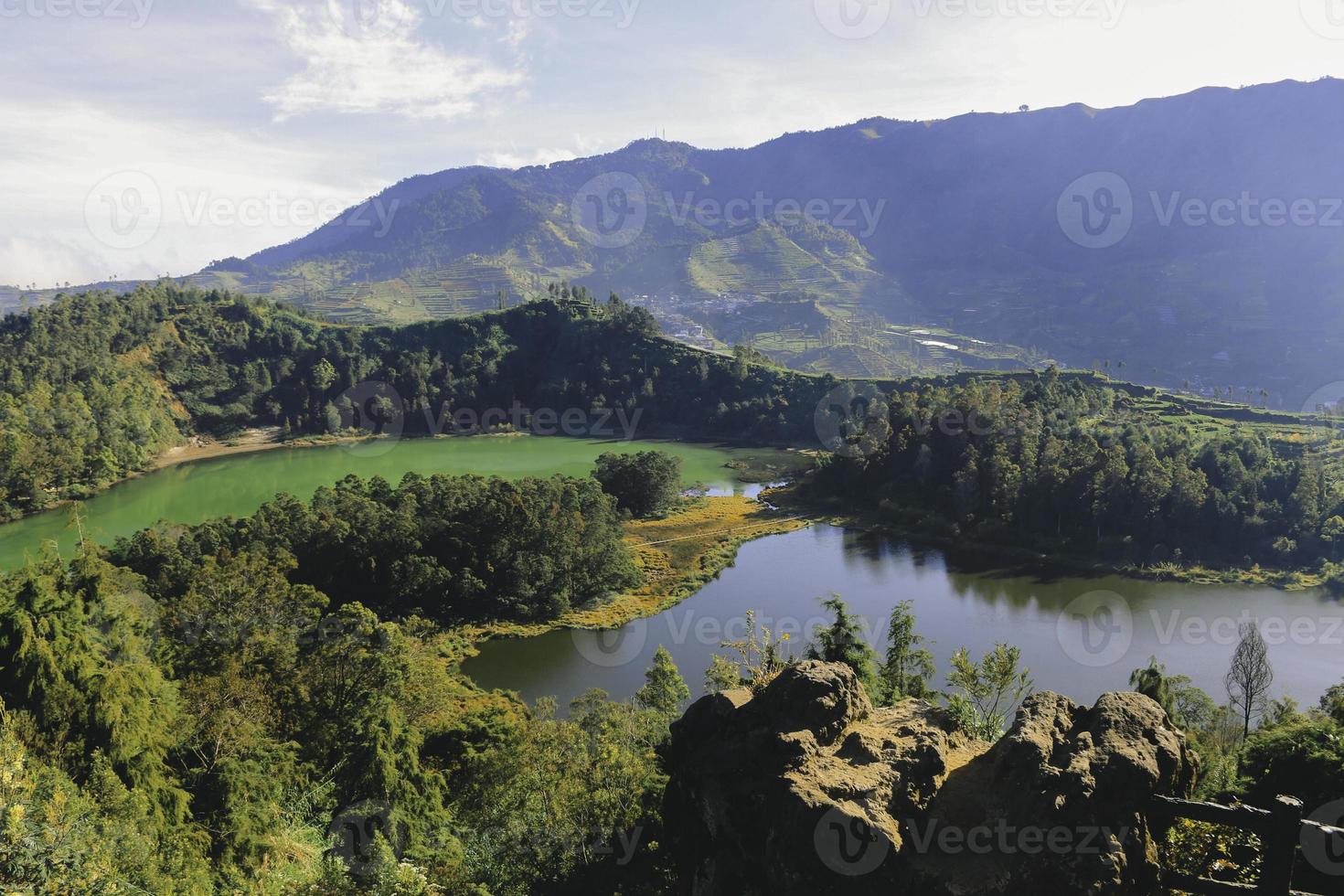 Morning view of Telaga Warna Lake with mountain background at Dieng Plateau, Central Java, Indonesia. Aerial View from Batu Pandang Ratapan Angin Hill photo