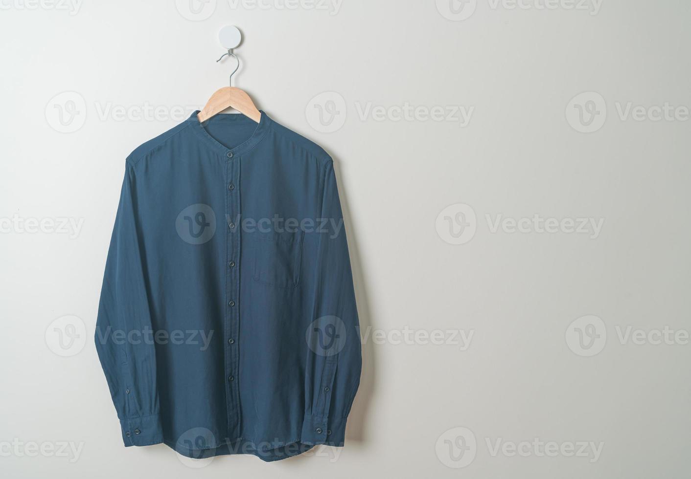 hanging shirt with wood hanger on wall photo