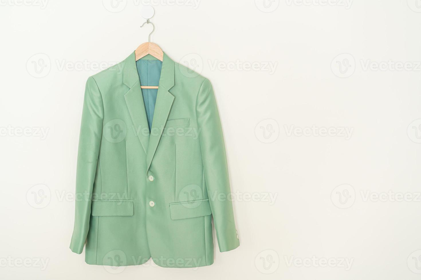 green suit hanging with wood hanger photo