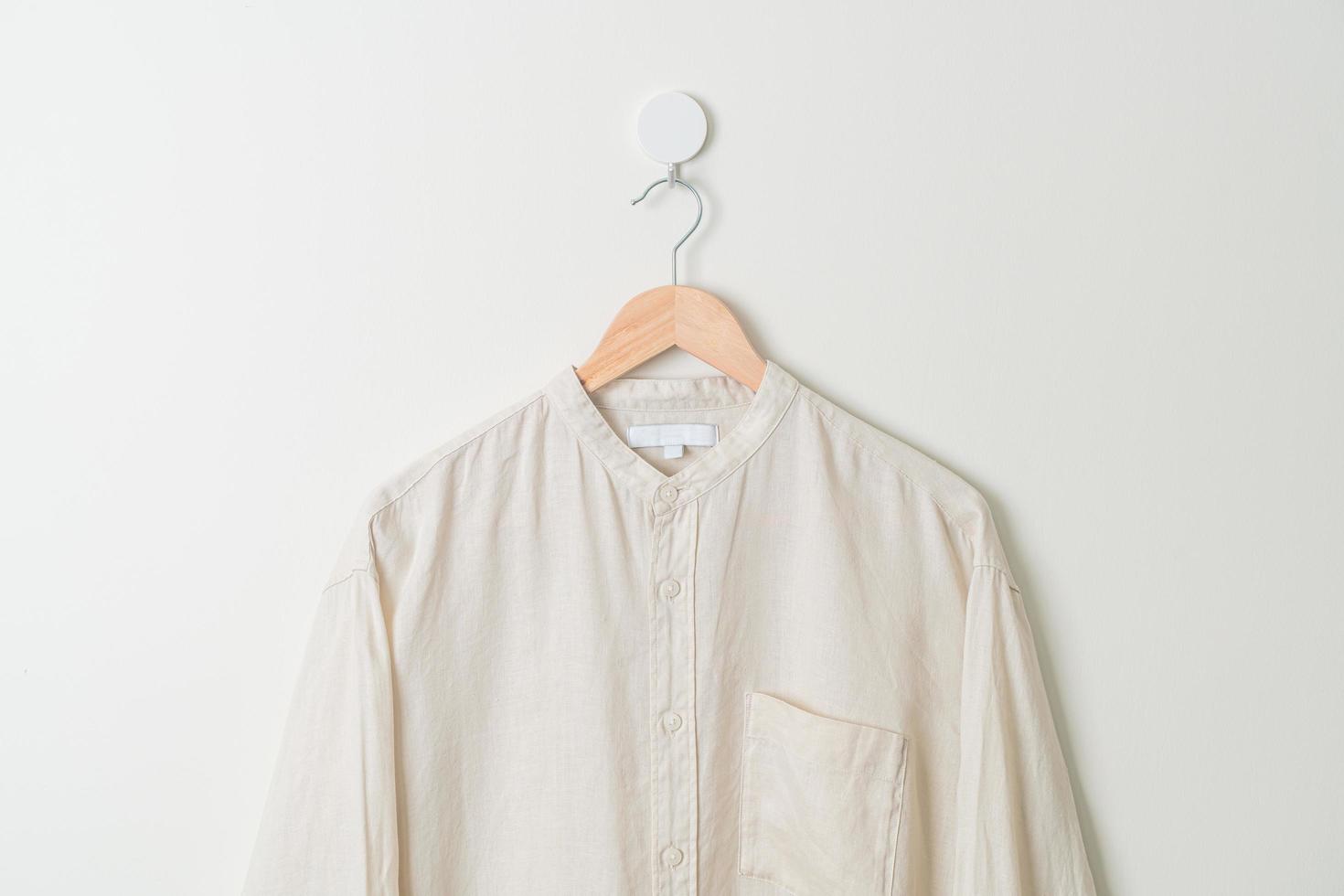 hanging shirt with wood hanger on wall photo