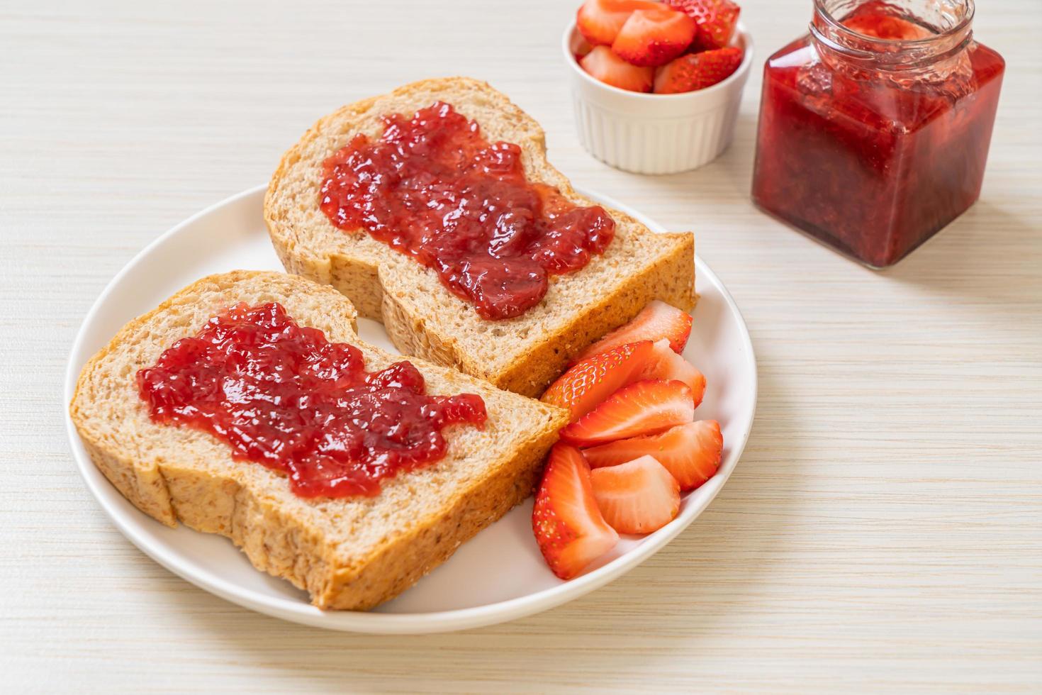 pan integral con mermelada de fresa y fresa fresca foto