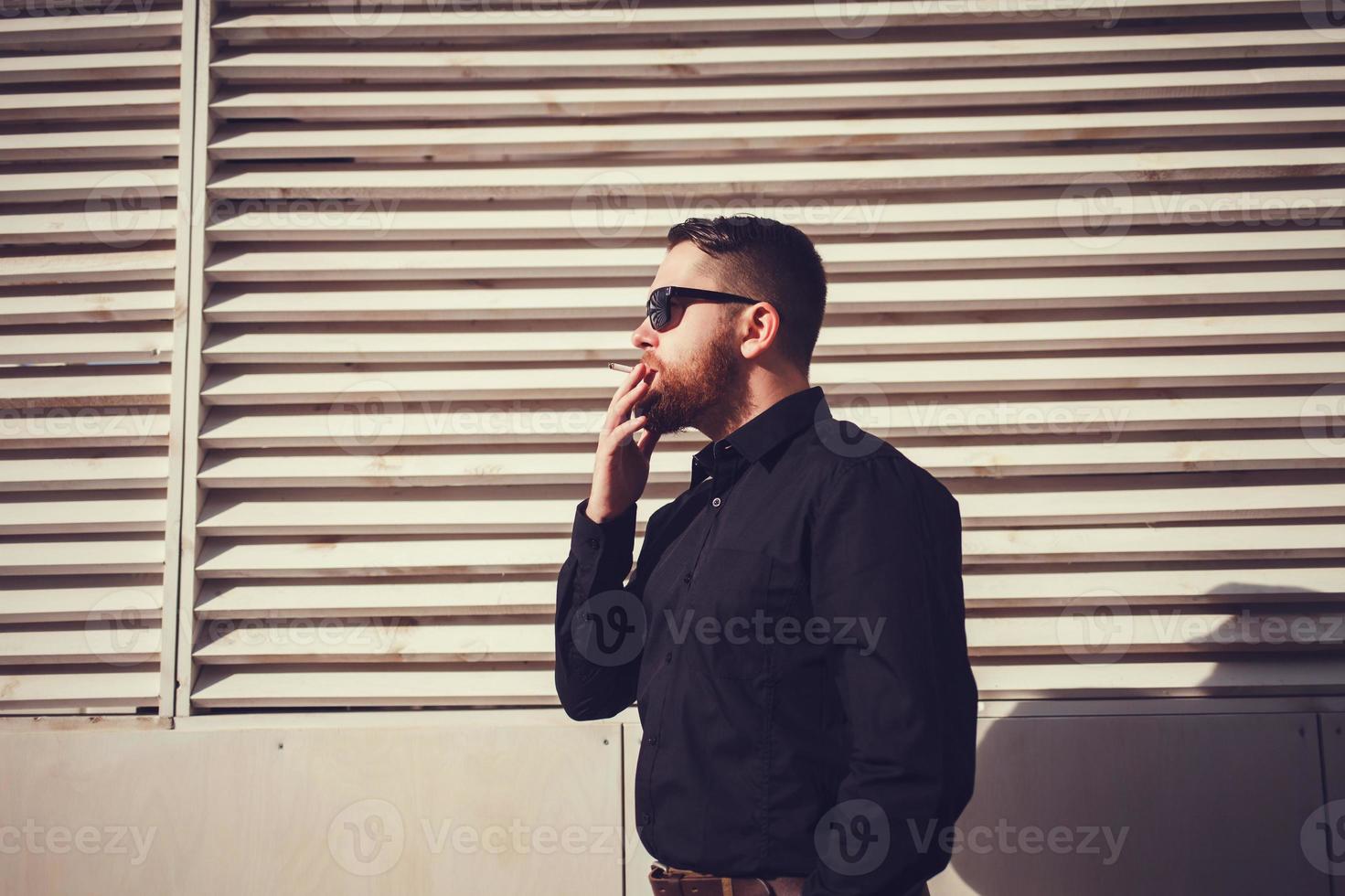 man in sunglasses smoking a cigarette photo