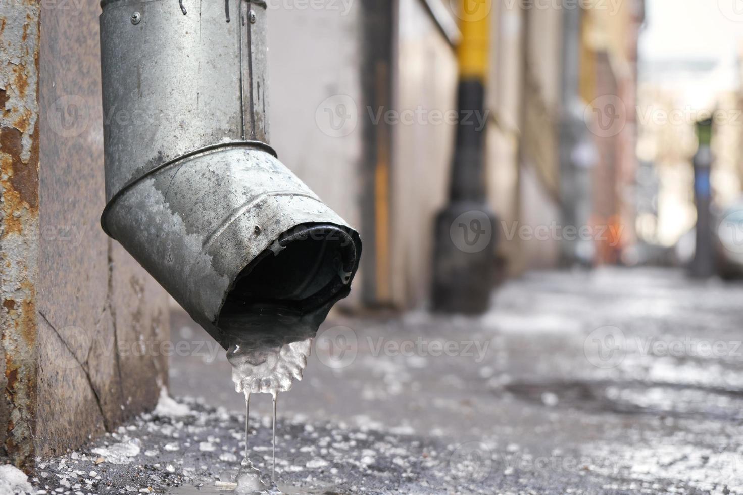 Drain pipe with frozen water in winter on Moscow street photo