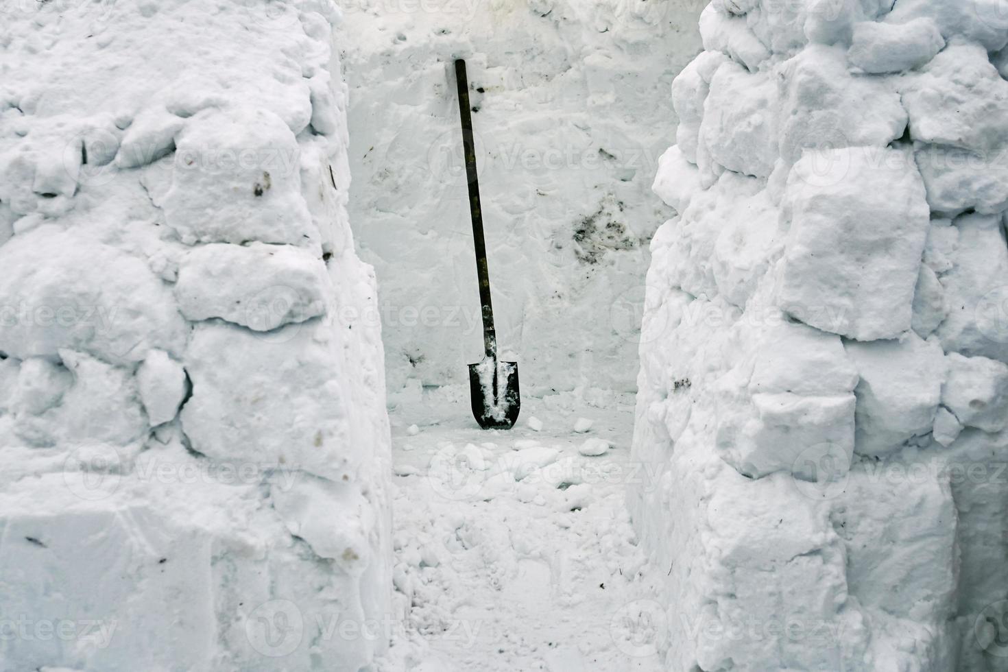 construcción de un iglú de casa de nieve a partir de ladrillos de nieve usando una pala foto