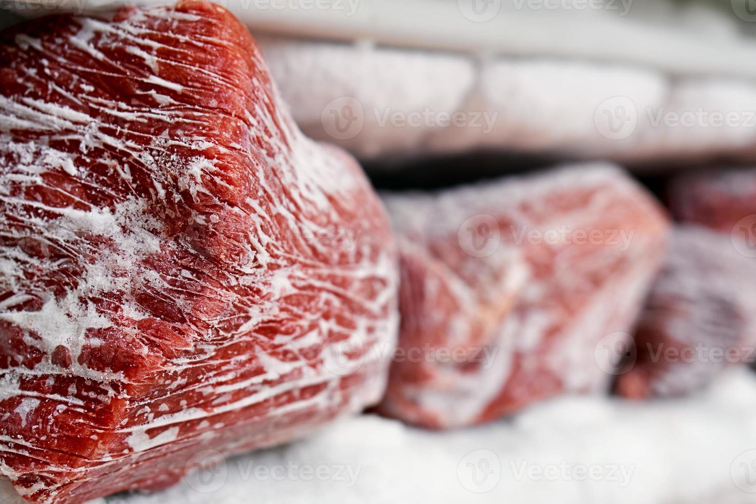 grandes trozos de carne roja en un congelador con una gran cantidad de hielo congelado y nieve foto