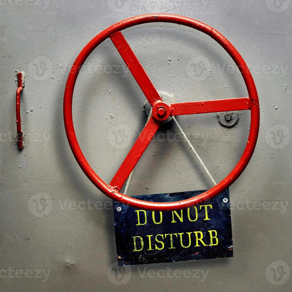 DO NOT DISTURB warning sign plate hanging on a hermetic bomb shelter armored door photo
