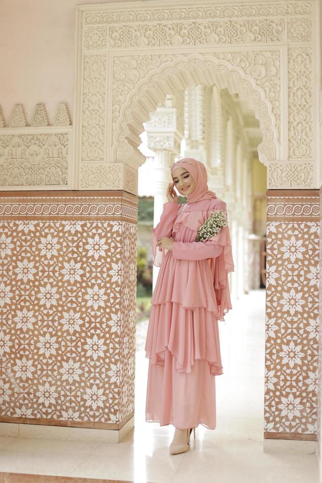 Full body portrait of lady use a wedding dress, wedding makeup on hijab. Malay or indonesia wedding dress, beauty or eidul fitri concept. Beautiful southeast asian muslim woman posing at the mosque photo