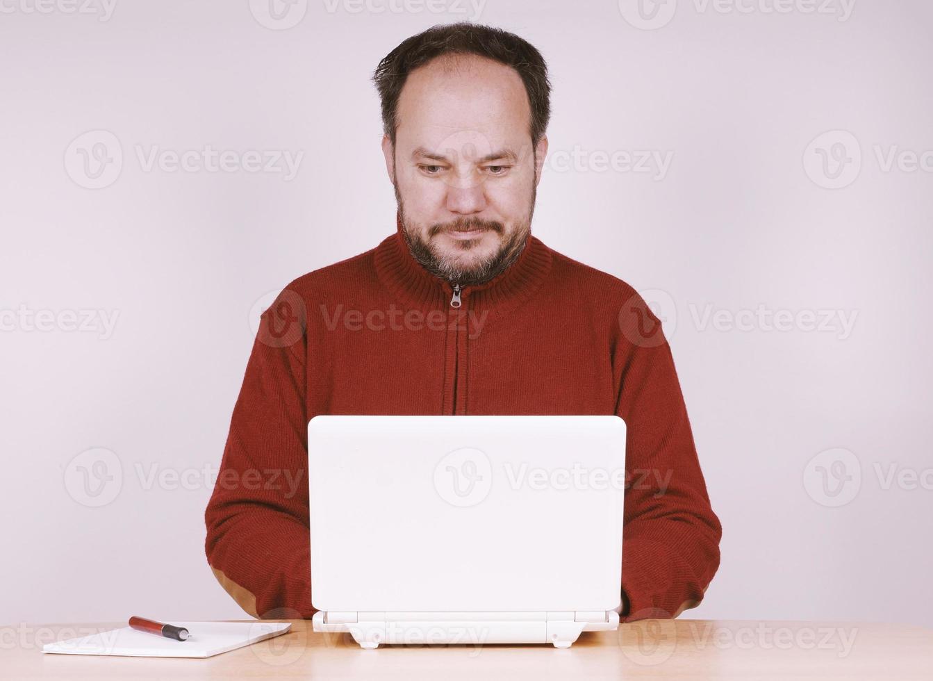hombre adulto medio que usa una computadora portátil netbook para mantenerse conectado foto