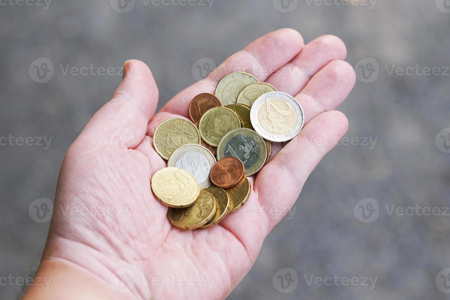 Un puñado de pequeñas monedas de céntimo de euro sueltas en la palma de la mano foto