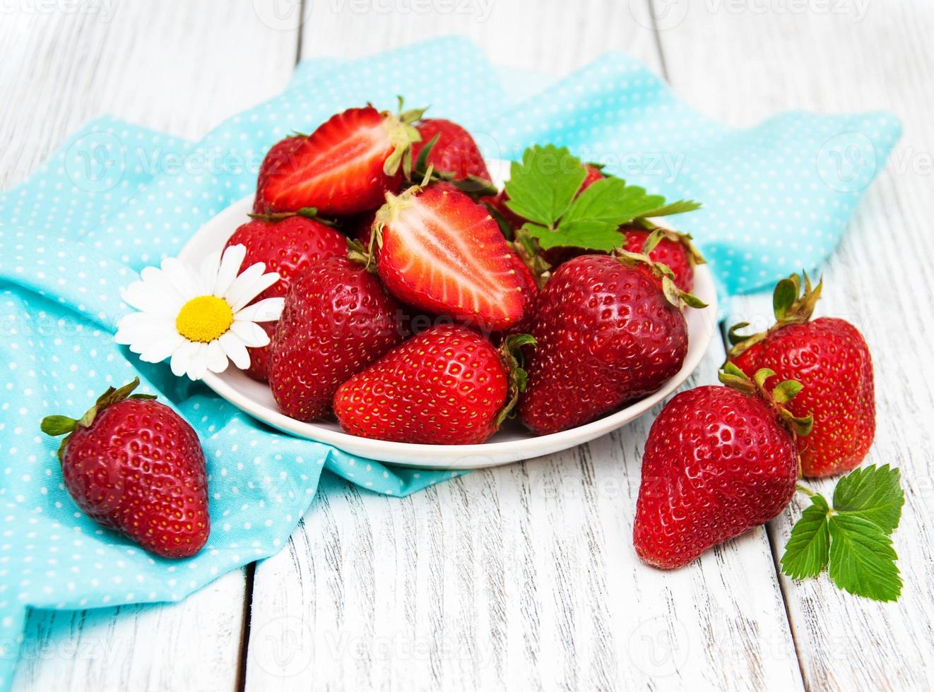 ripe strawberries on wooden table photo