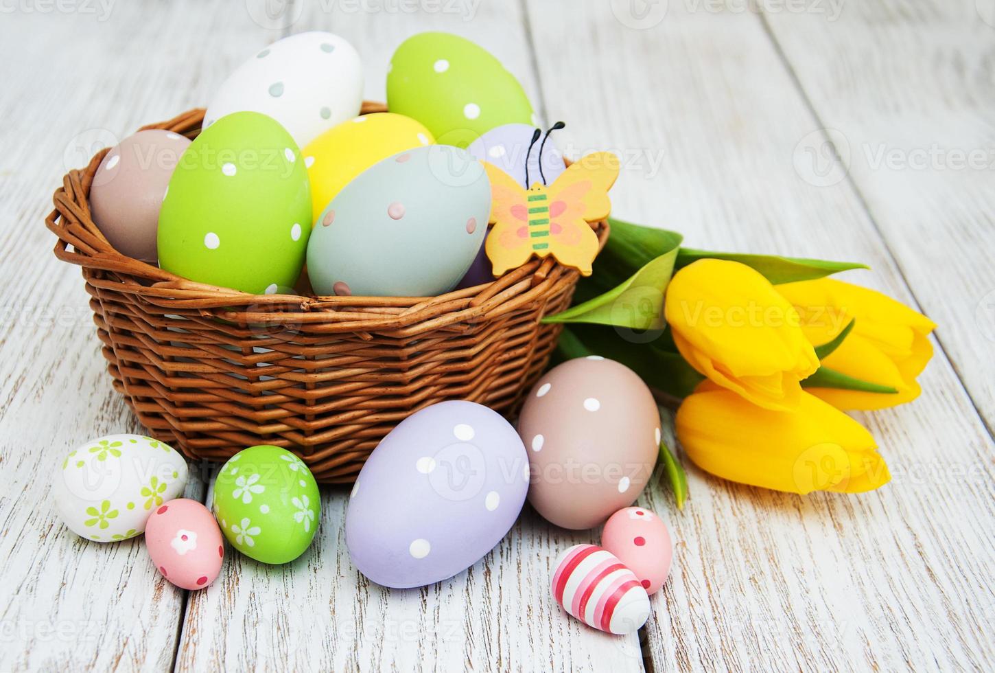 canasta con huevos de pascua y tulipanes foto