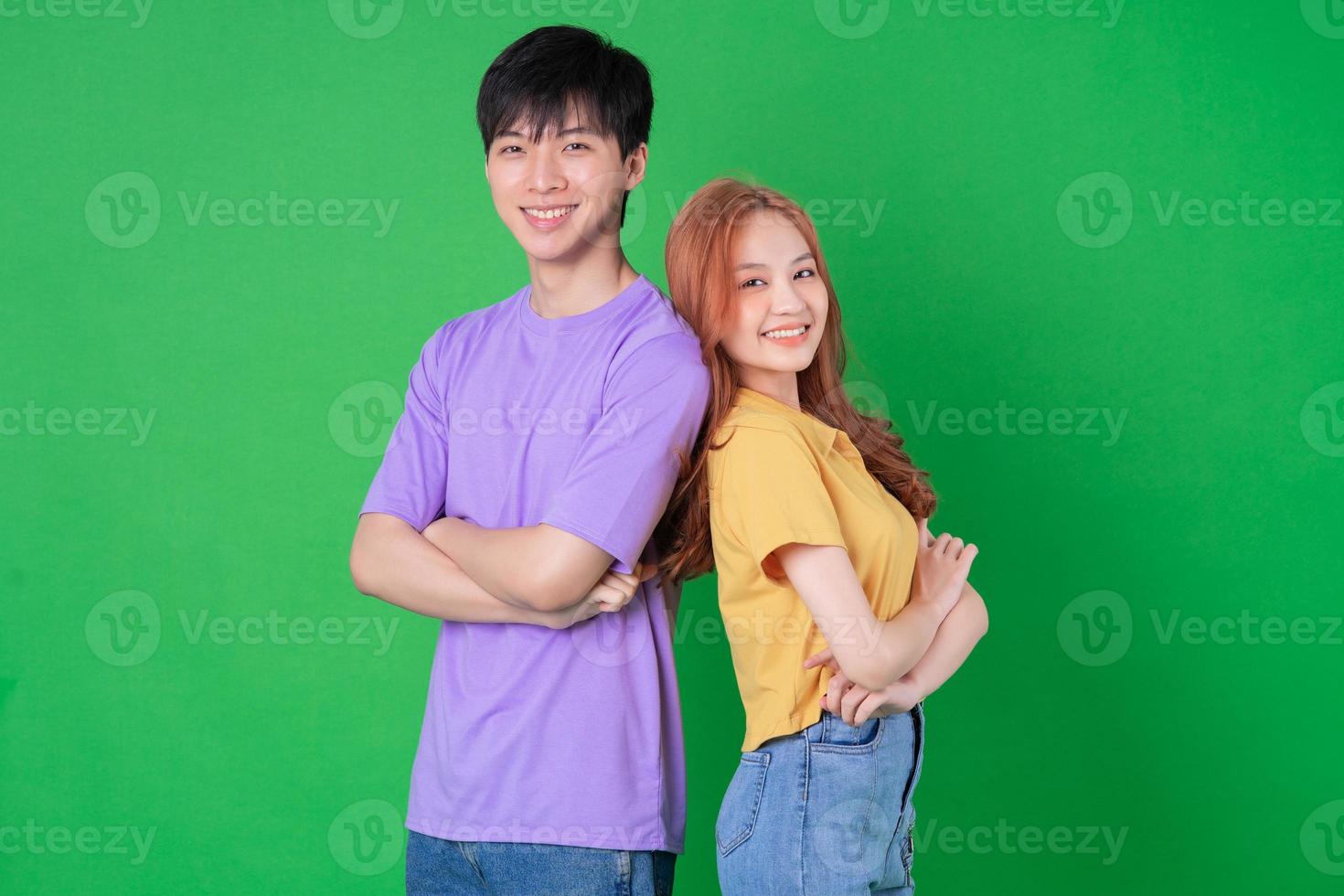 joven pareja asiática posando sobre fondo verde foto