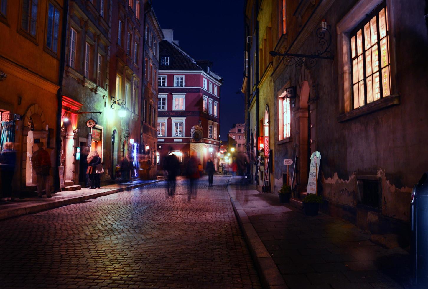 siluetas que se mueven por la noche en un centro antiguo de la ciudad en europa foto