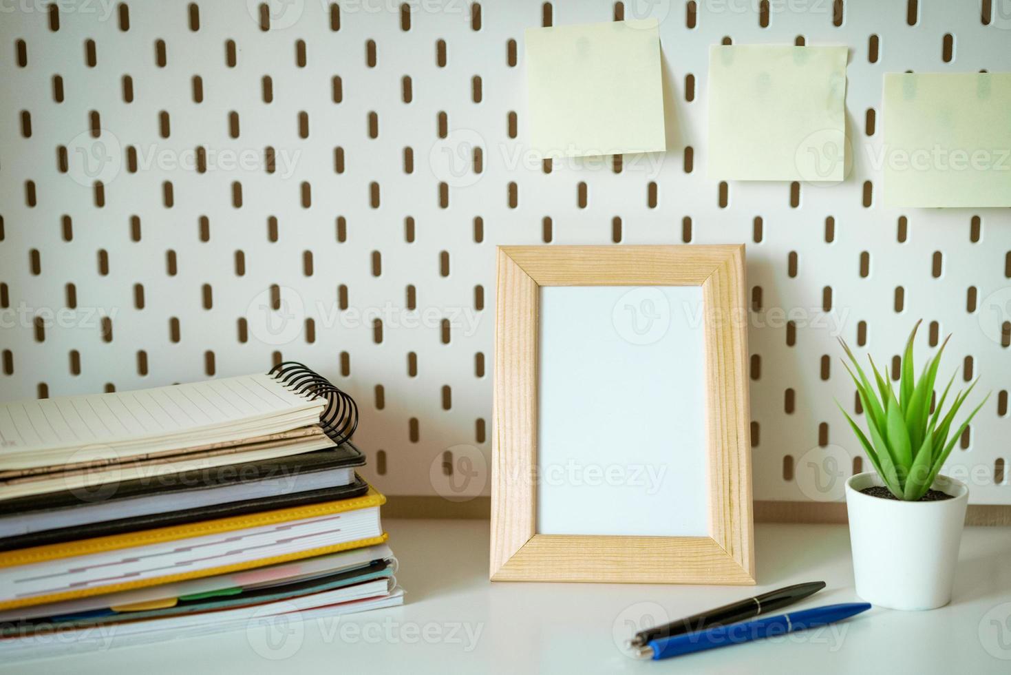 Desktop with notebooks pencils and photo frame