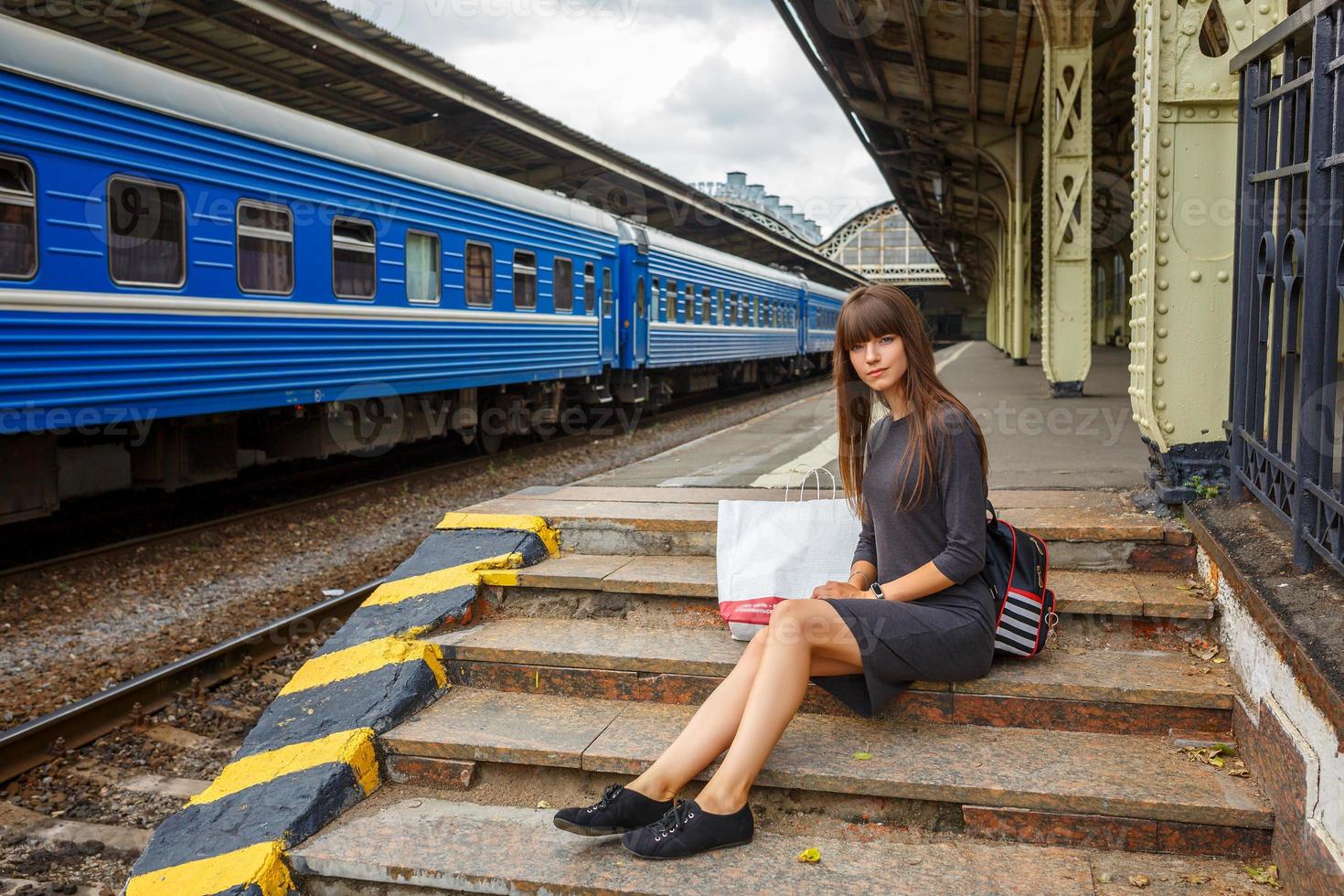 beautiful young woman standing on the platform of railway station travel concept photo