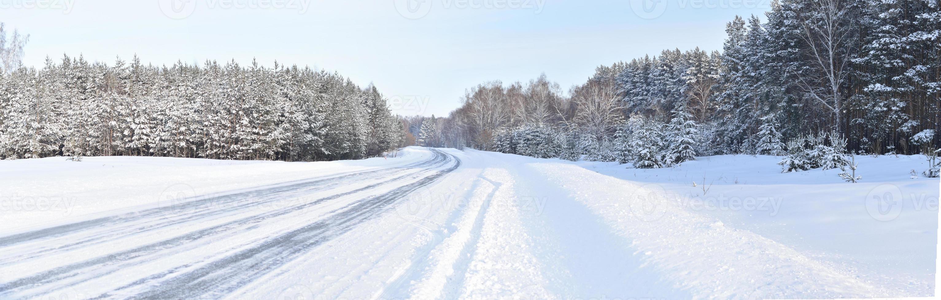 panorama invierno camino cubierto de nieve y bosque foto