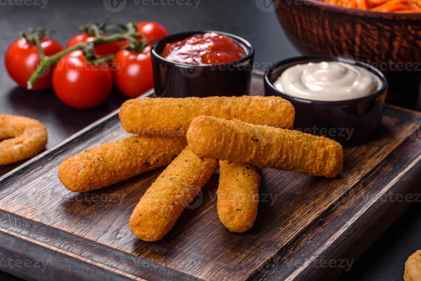 Breaded mozzarella cheese sticks served with tomato sauce photo