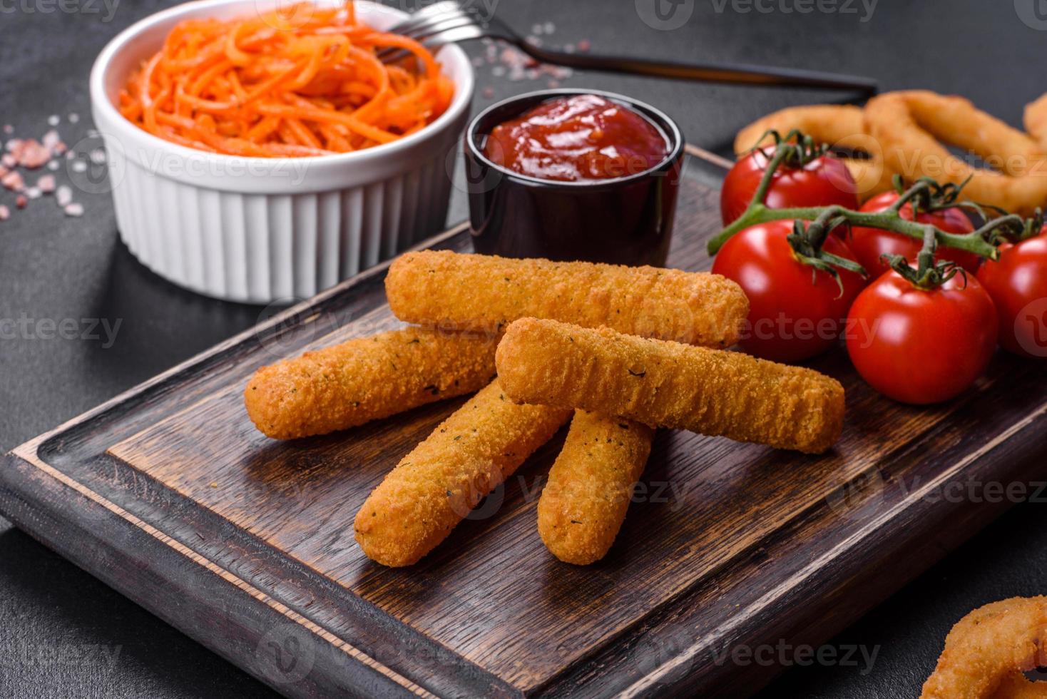 Breaded mozzarella cheese sticks served with tomato sauce photo