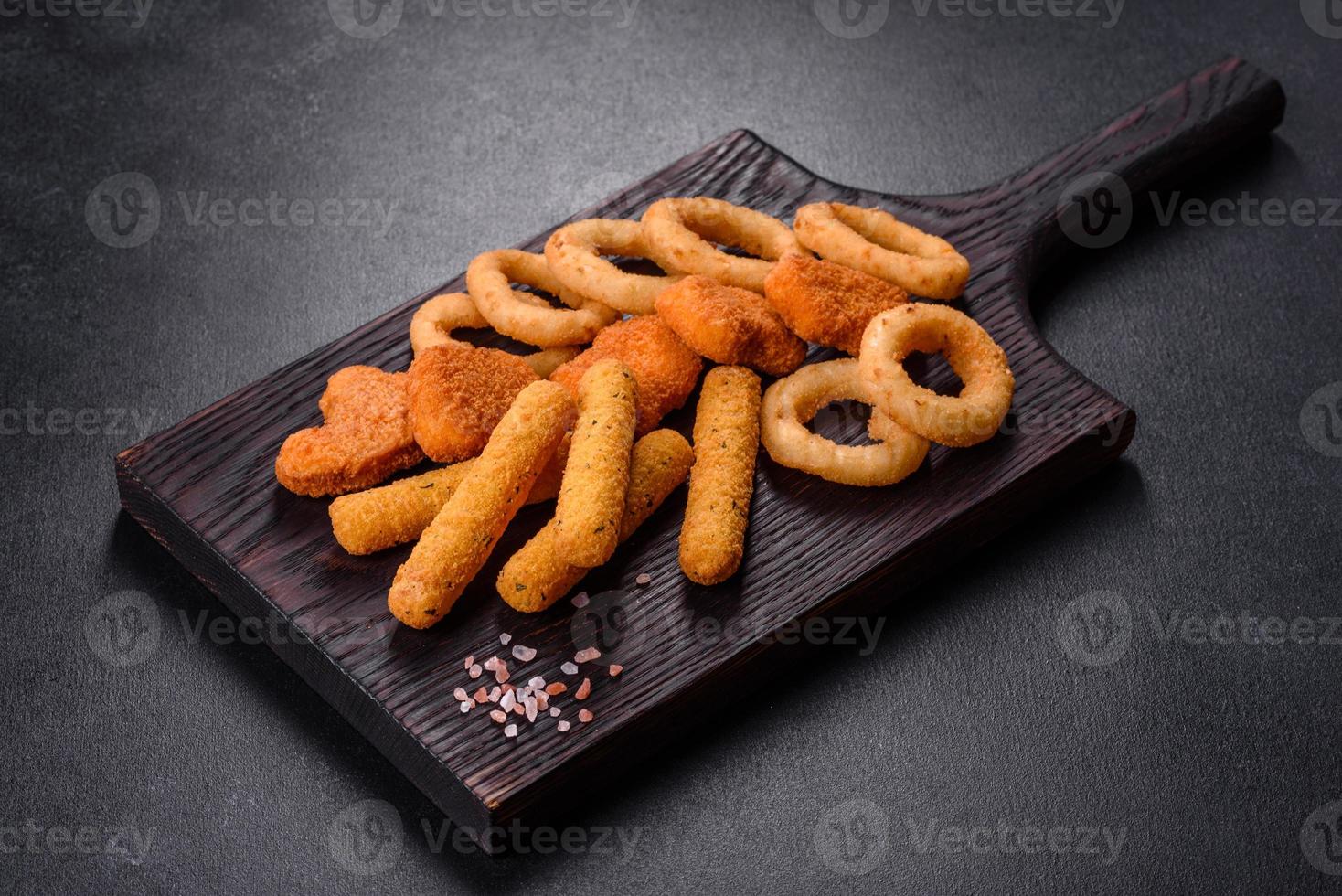 Snack platter - cheese sticks, chicken nugget, onion rings mix of snacks and sauces photo
