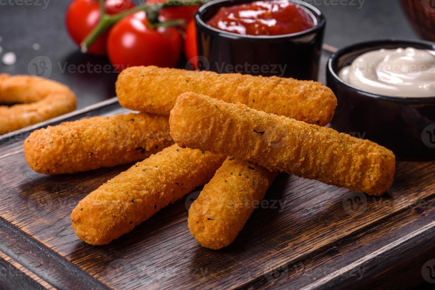 Breaded mozzarella cheese sticks served with tomato sauce photo