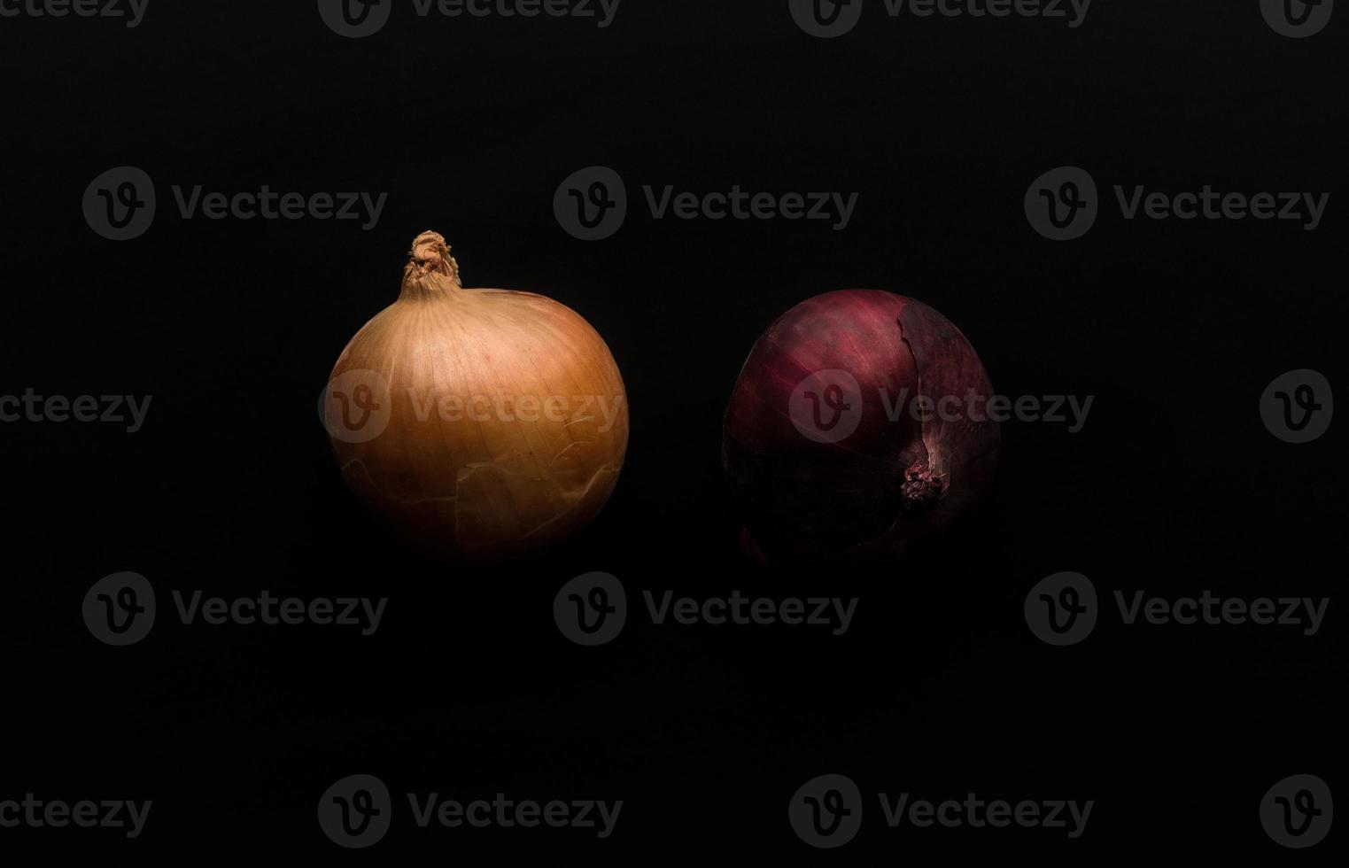 a few raw onions on black background photo