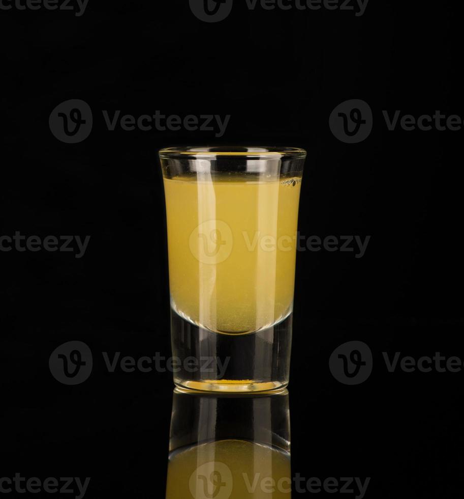 shot glass with alcohol on a dark background photo