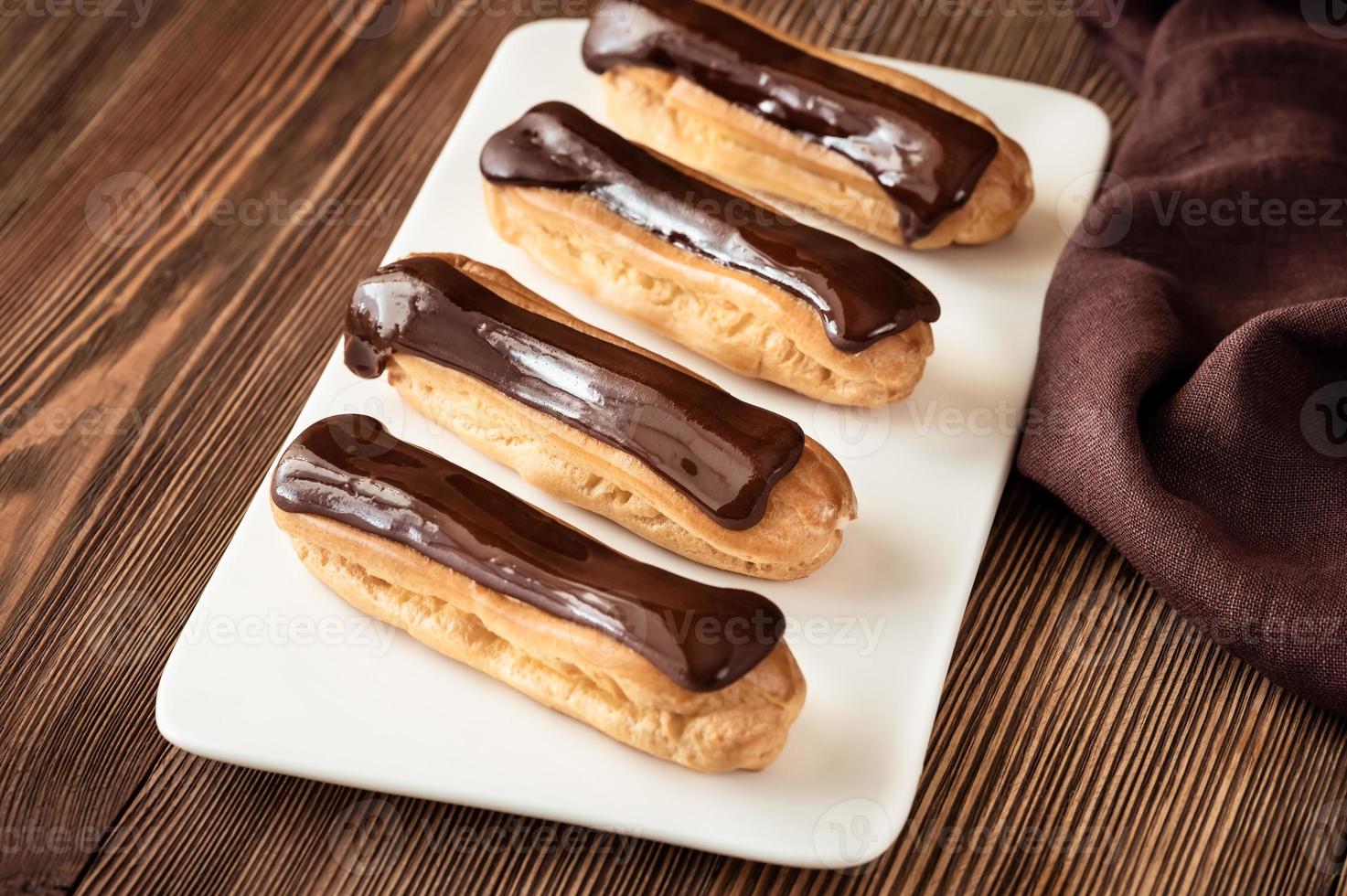 Eclairs with chocolate topping photo