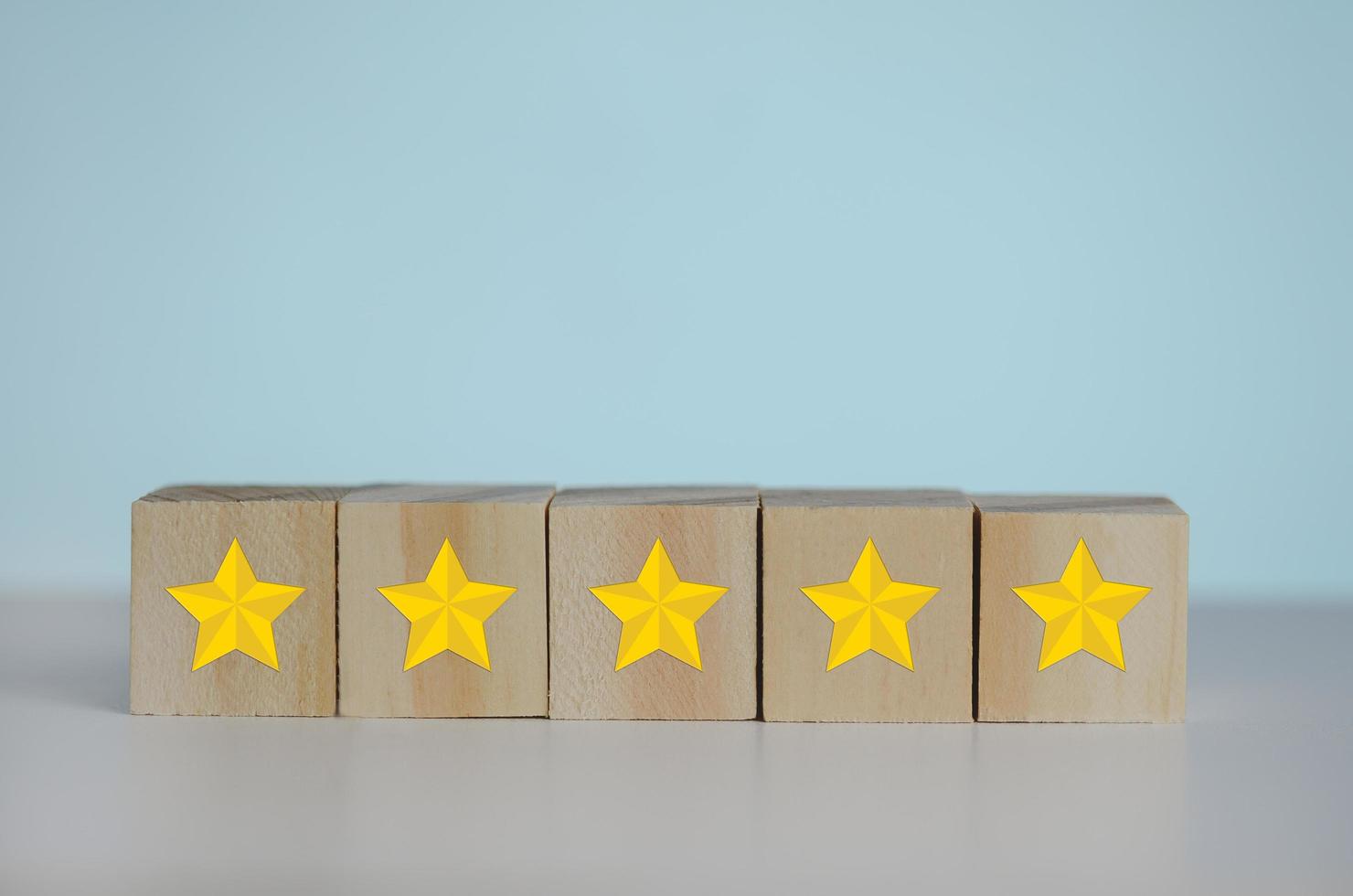 Wooden cubes with yellow star five symbol on background and copy space.Customer experience, satisfaction and best excellent services rating concepts. photo