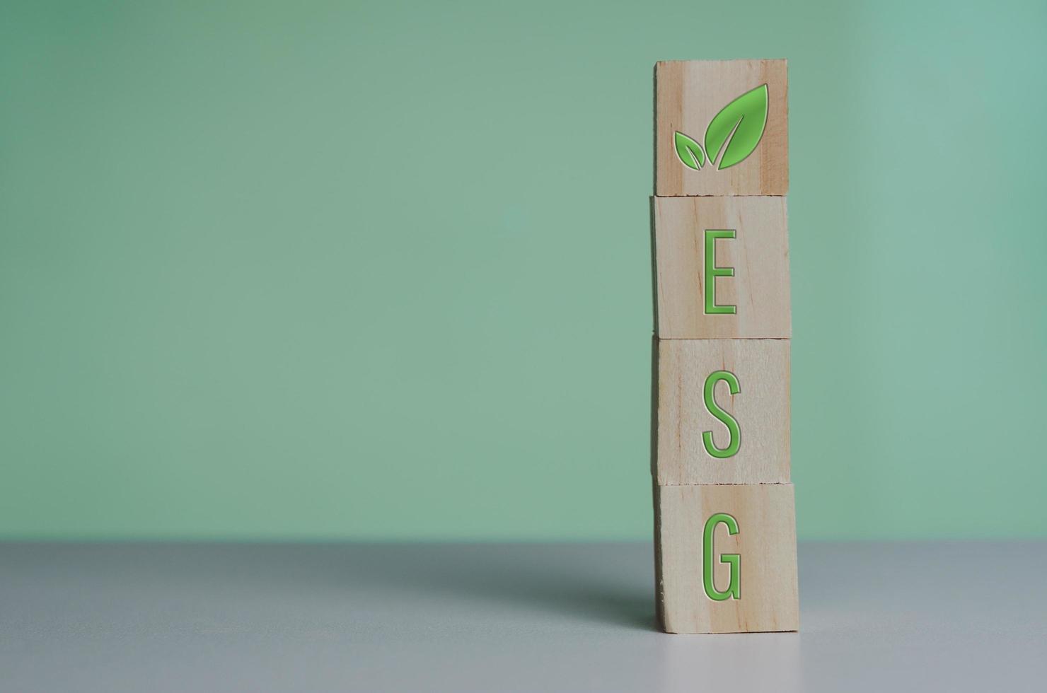 Wooden cubes with esg symbol Environmental Social Governance  on the green background and copy space. photo