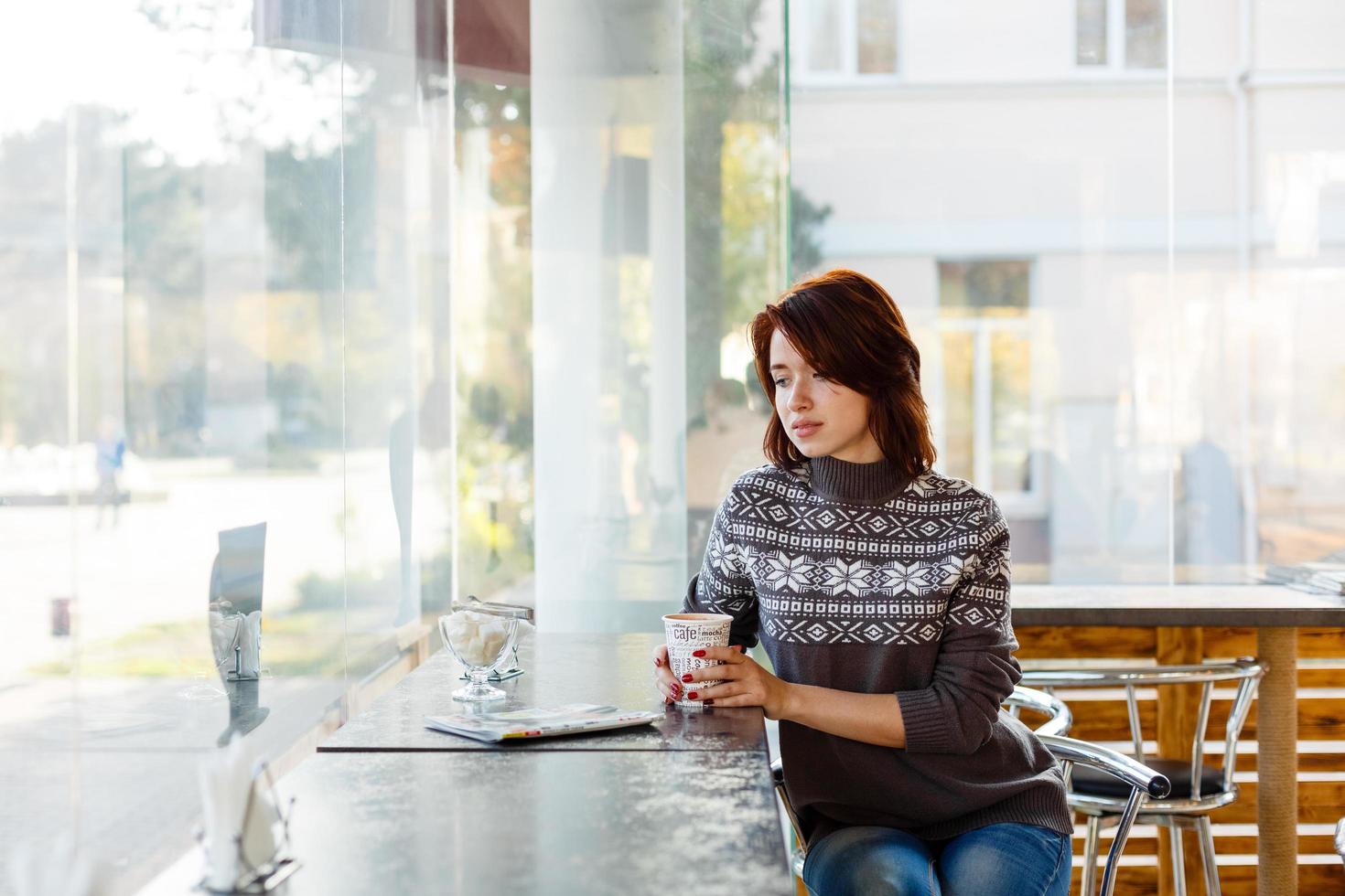 Portrait of charming young woman with friendly smile, brunette in a knitted photo