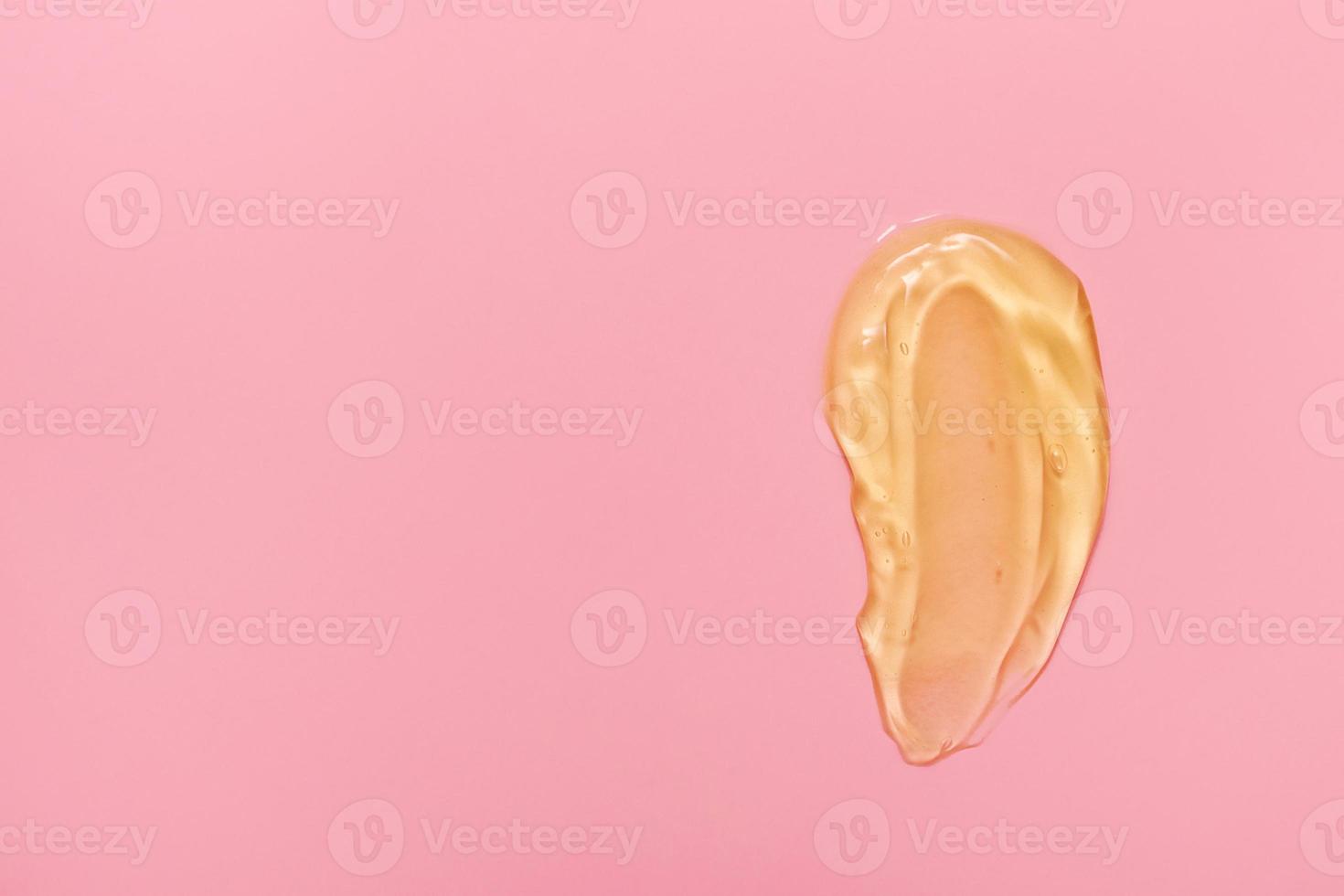 Gel cosmetic smears for skin care on a pink background, cream, peeling, milk, lotion, drops texture. Closeup with copy space. photo