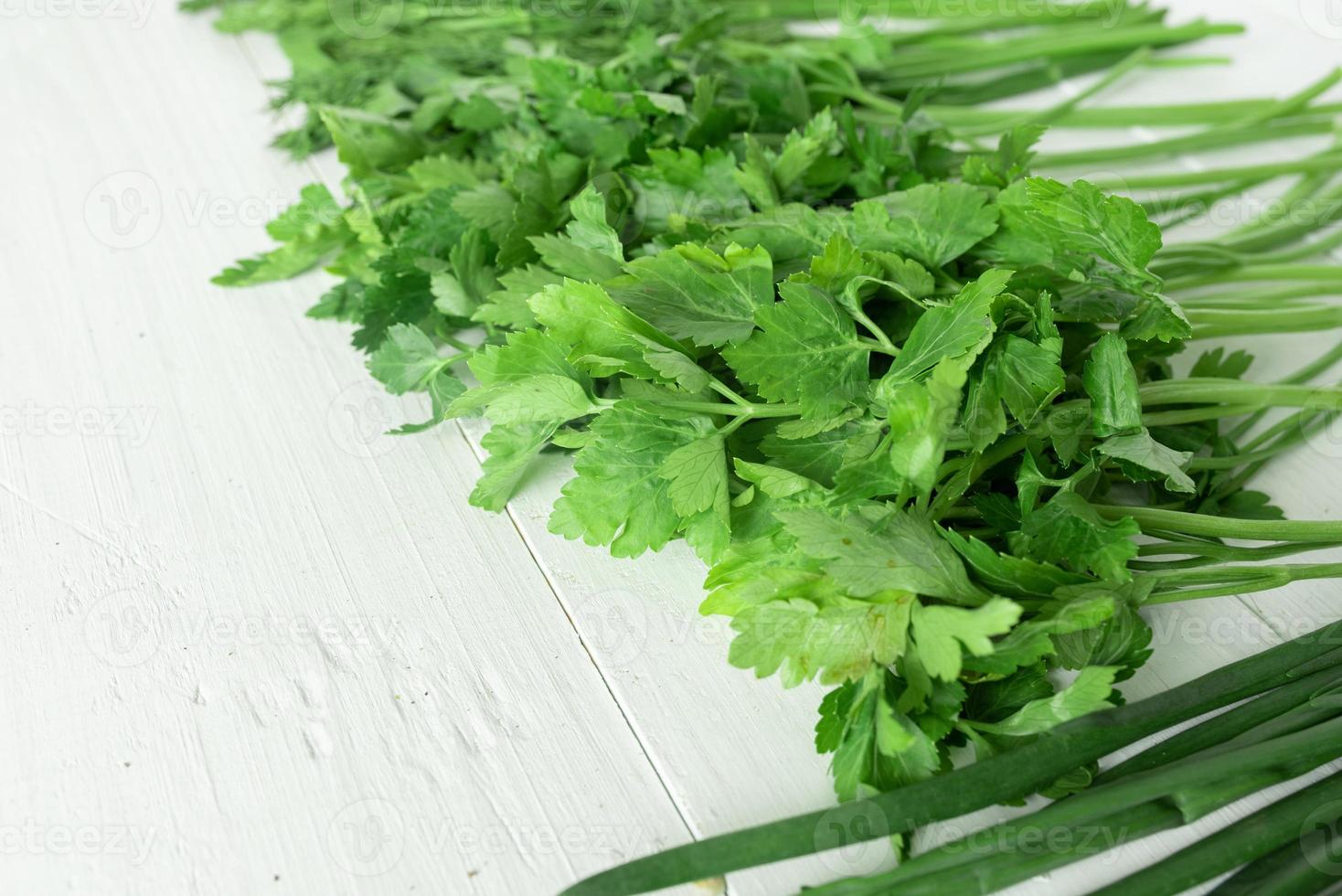 Set of greens for salad on a white wooden background. Place for text. photo