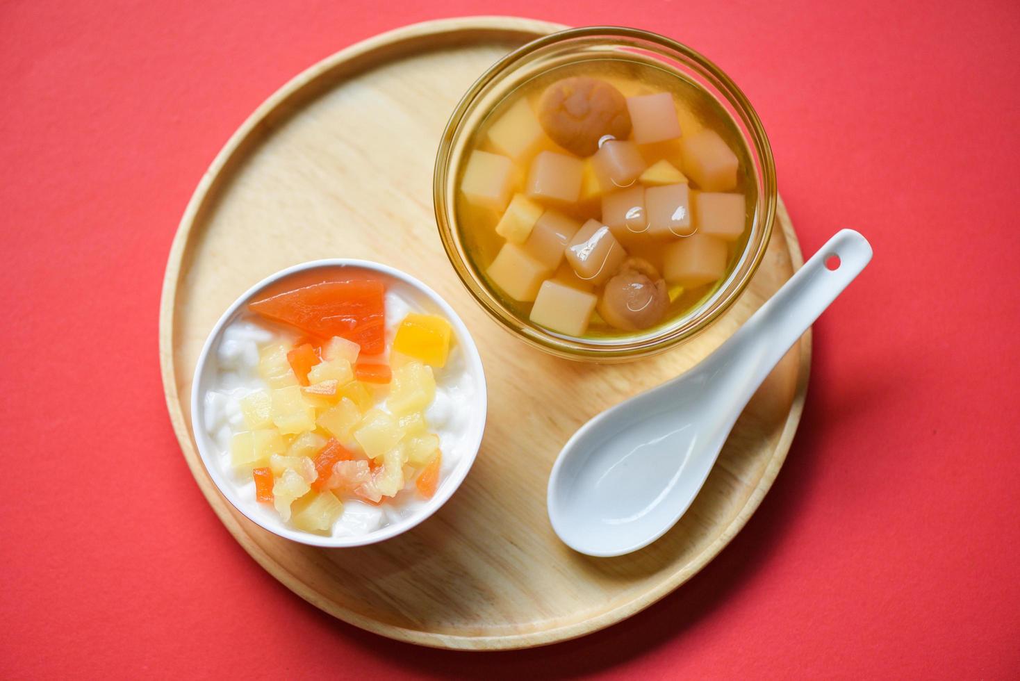 Chinese desserts, milk pudding fruit salad and Mix ginkgo nuts cassava syrup coconut jelly in longan juice on glass bowl, Thai and Chinese longan date soup Asian dessert sweets photo