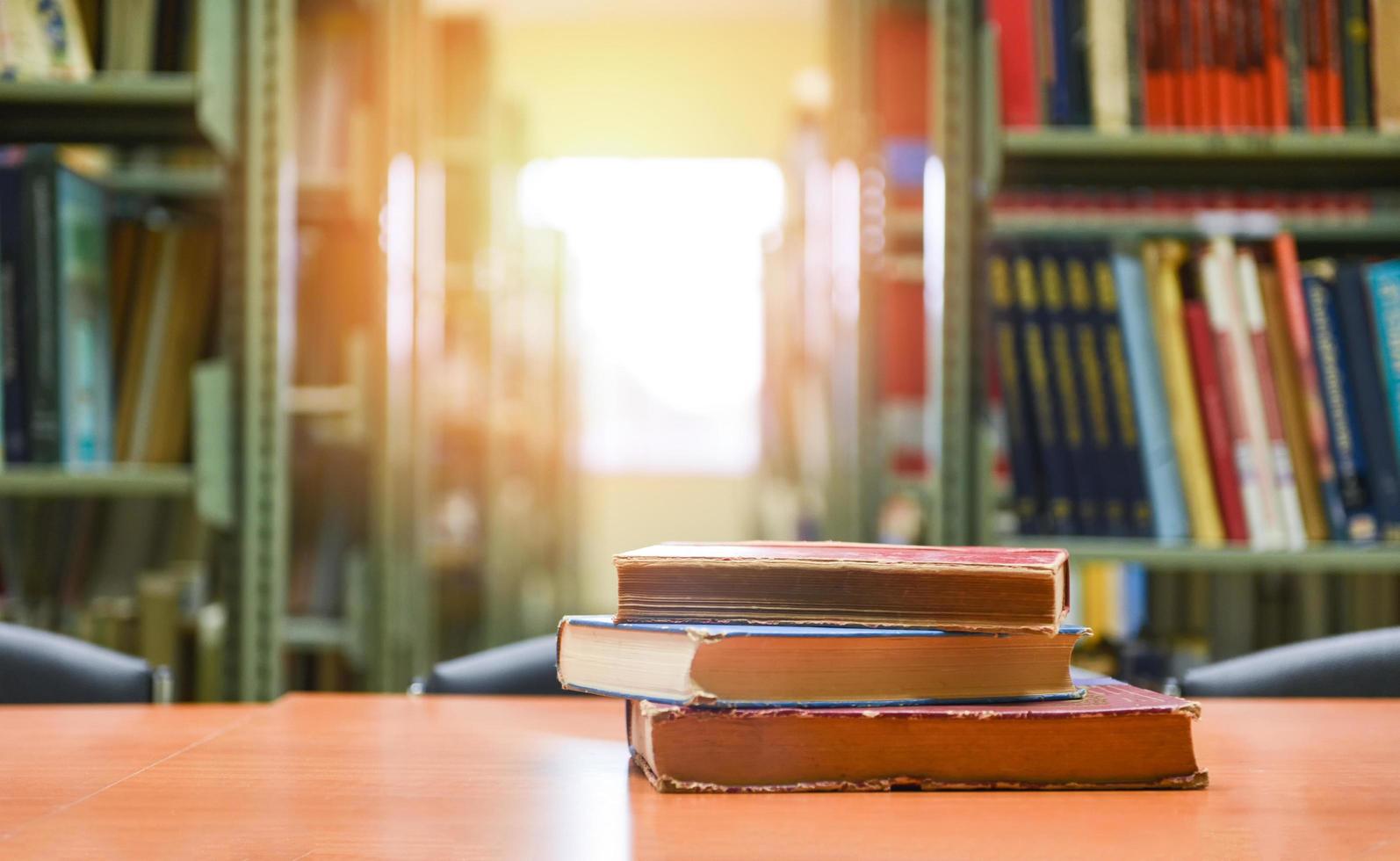 libros antiguos en una mesa de madera - pila de libros en la sala de la biblioteca para los antecedentes empresariales y educativos, concepto de regreso a la escuela foto