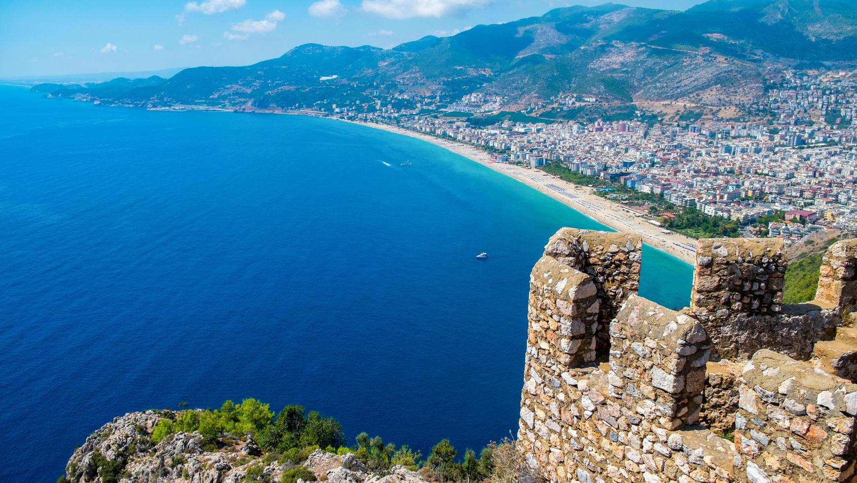 Alanya beach top view on the mountain with coast ferry boat on blue sea and harbor city background - Beautiful cleopatra beach Alanya Turkey landscape travel landmark photo