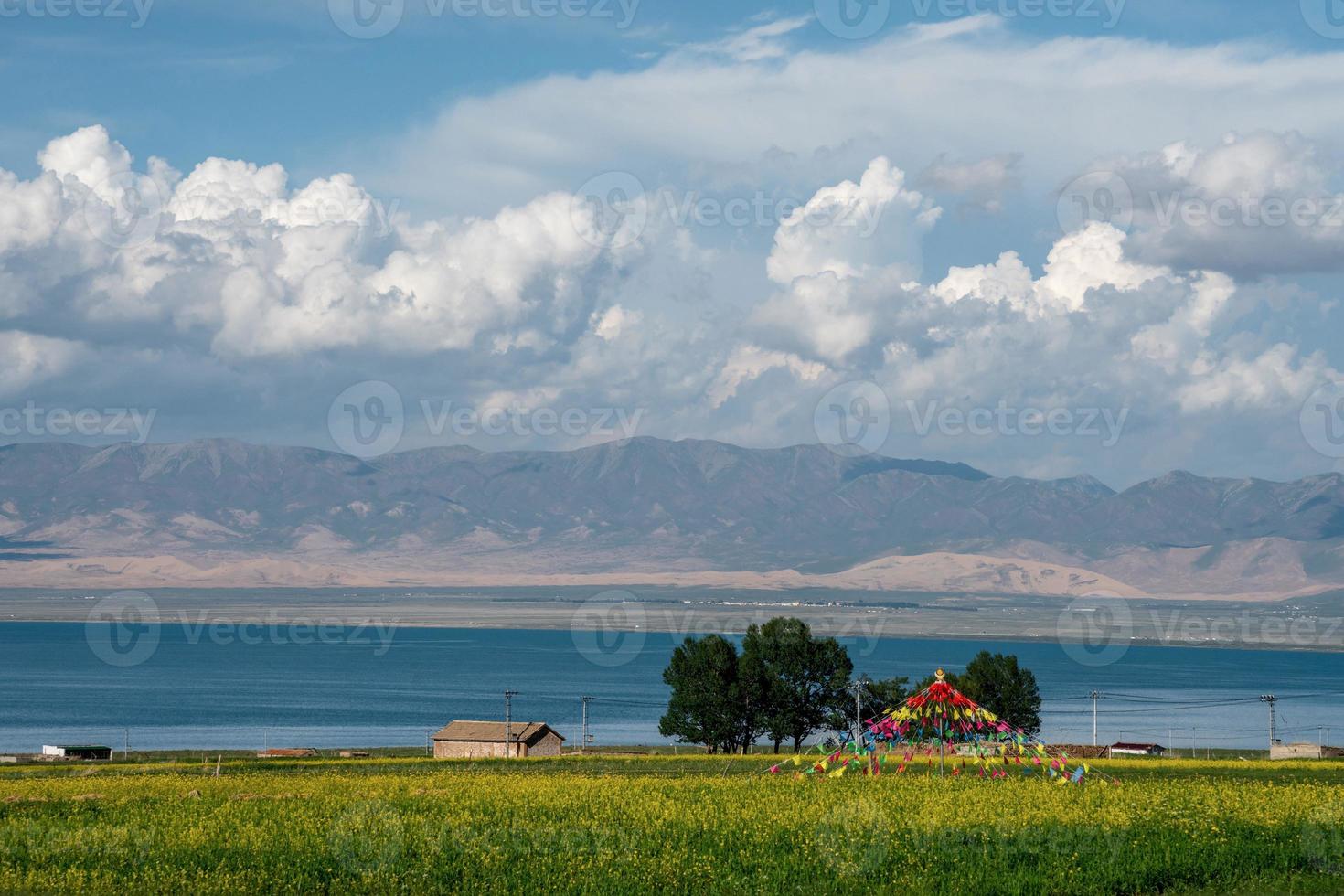 The blue sky and white clouds beside Qinghai Lake, as well as some tents and prayer flags on the grassland photo