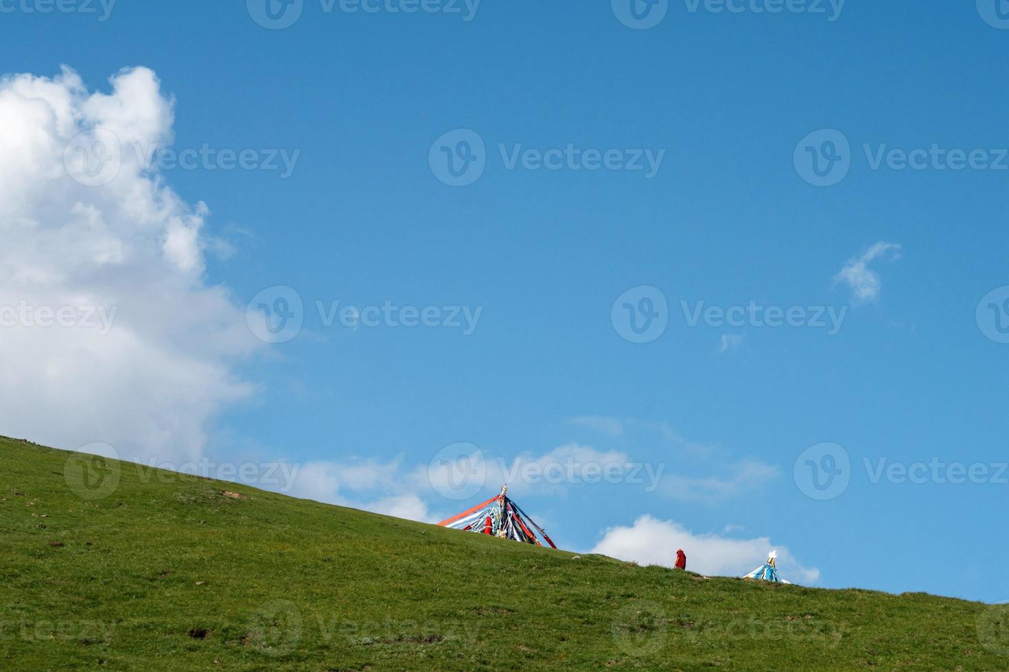 The blue sky and white clouds beside Qinghai Lake, as well as some tents and prayer flags on the grassland photo