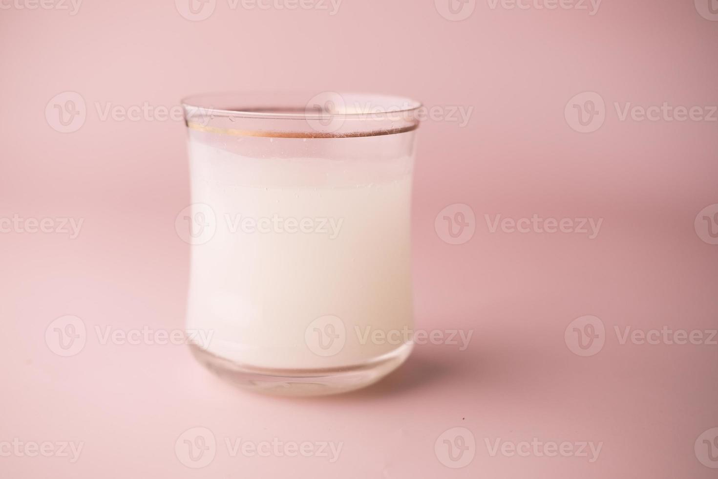 Effervescent soluble tablet pills and glass of water on purple background photo