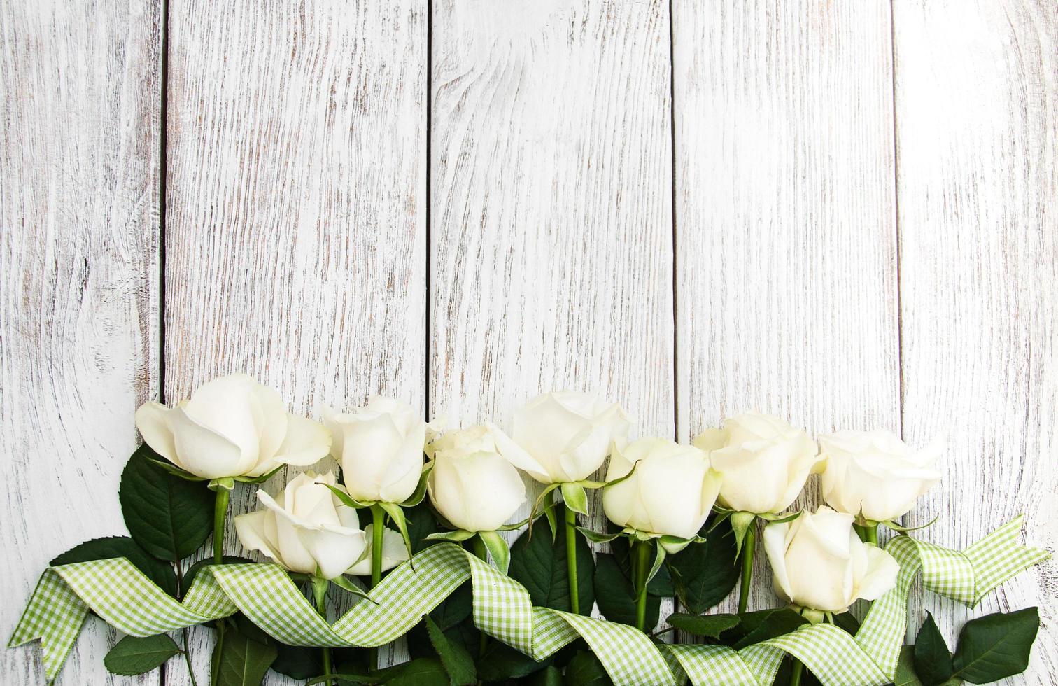 White roses on a wooden table photo