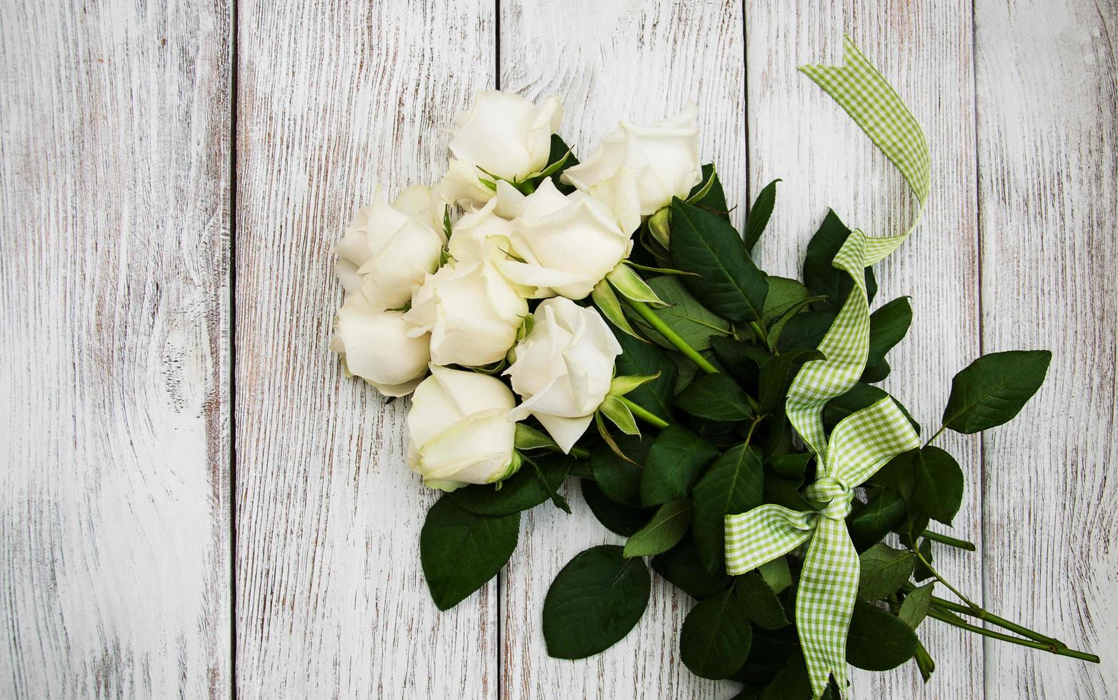 rosas blancas en una mesa de madera foto